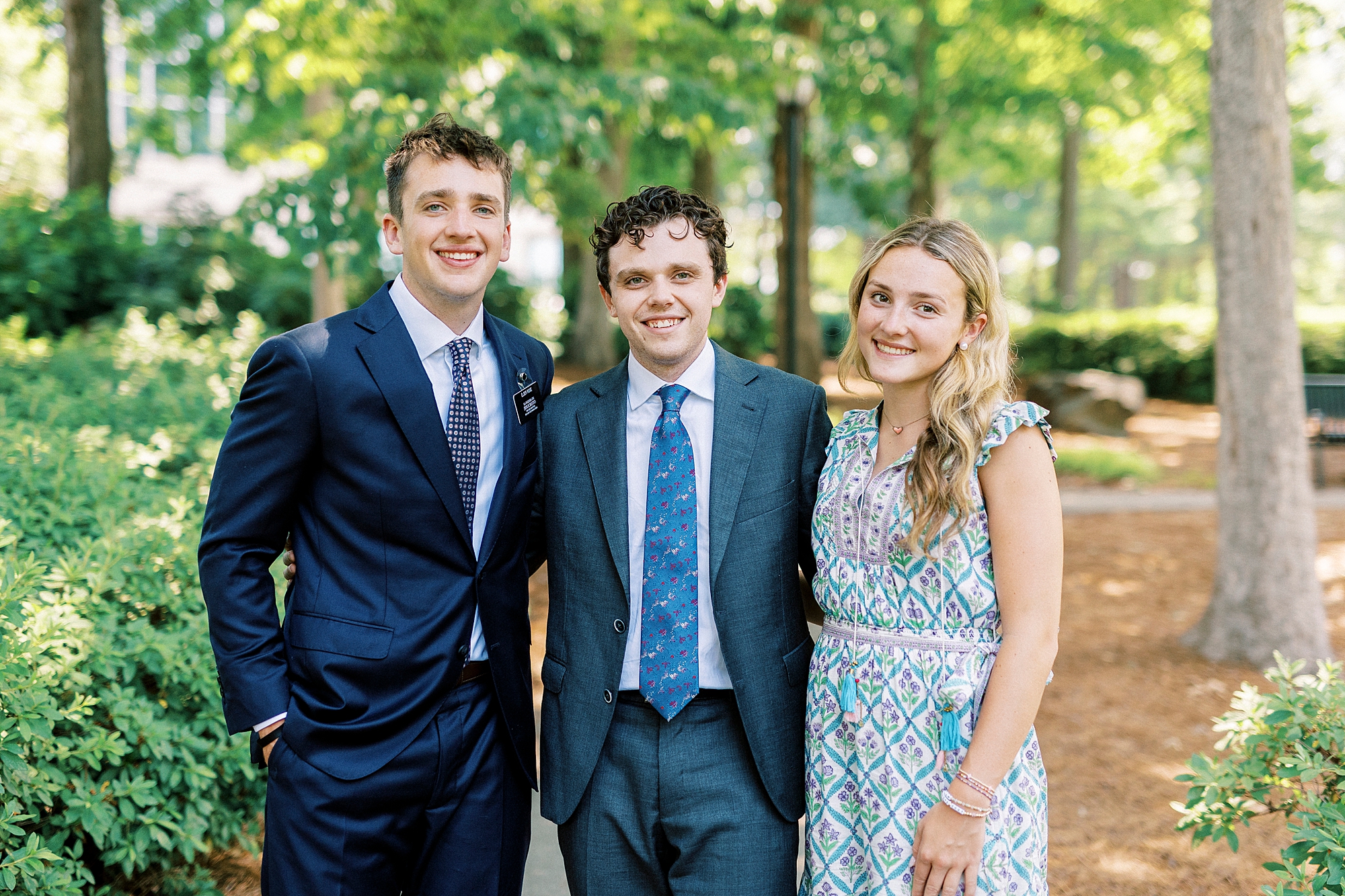 three teenage siblings stand together in Cullman Park