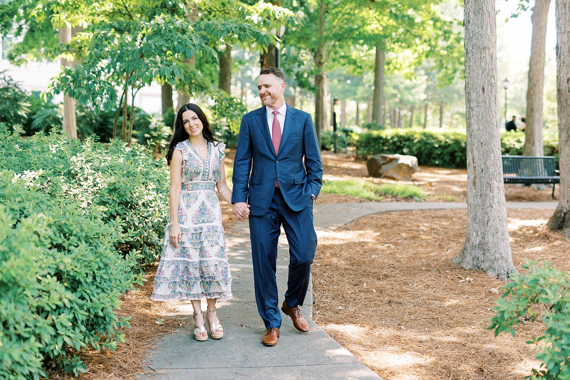parents hold hands walking down path in Cullman Park