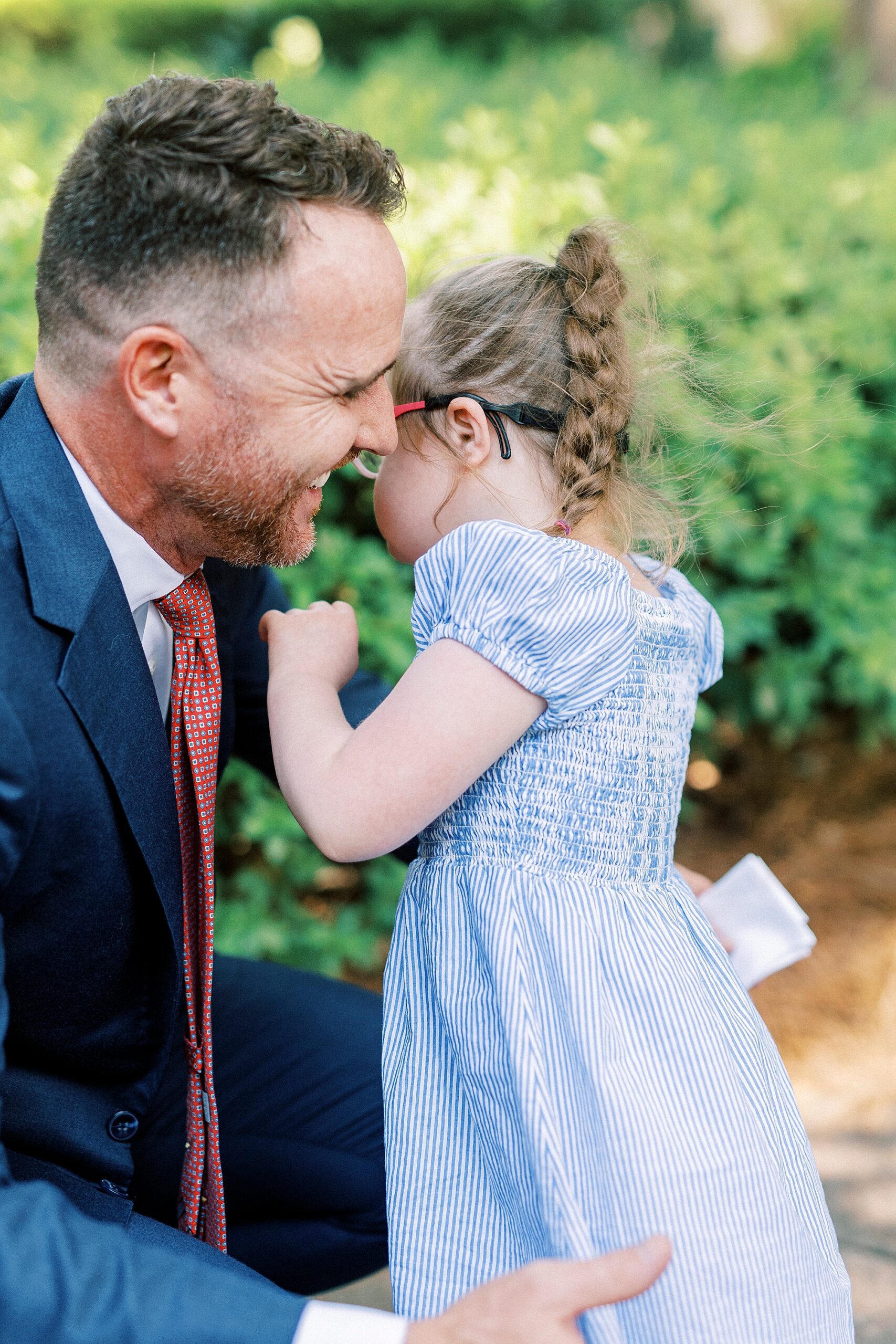 girl with Down syndrome hugs father on pathway in Cullman Park