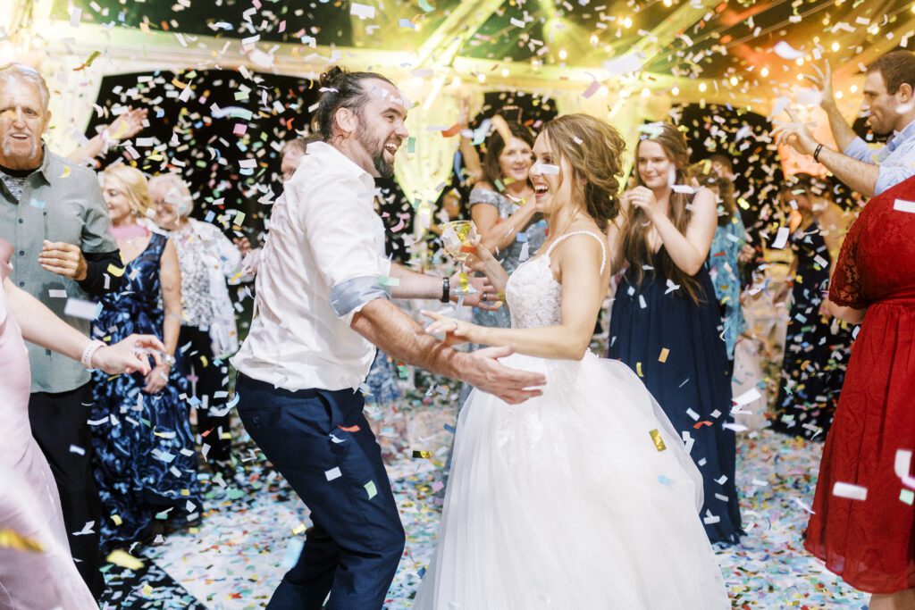 bride and groom dancing with confetti falling around them 
