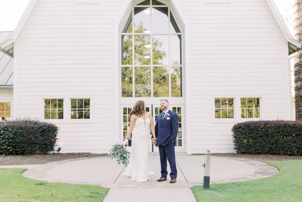 bride and groom outside large white barn at dairy barn in fort mill South Carolina
