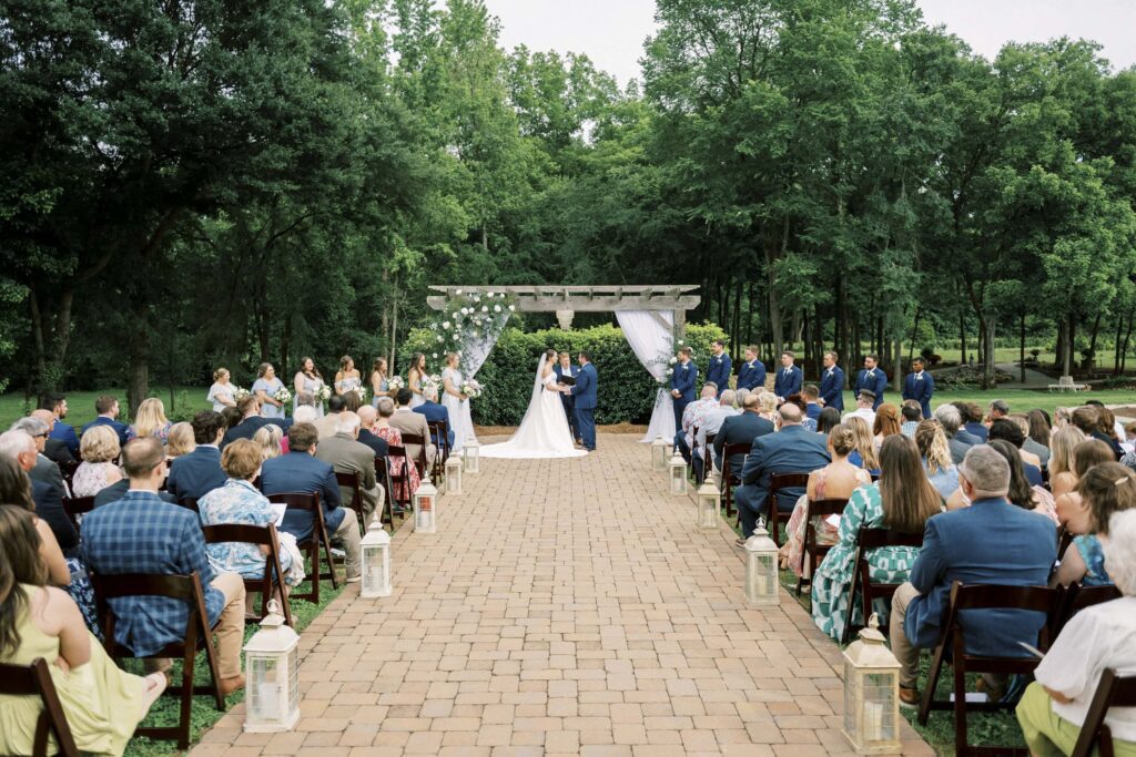 outdoor spring wedding ceremony under wooden arch at low meadows estate in belmont North Carolina