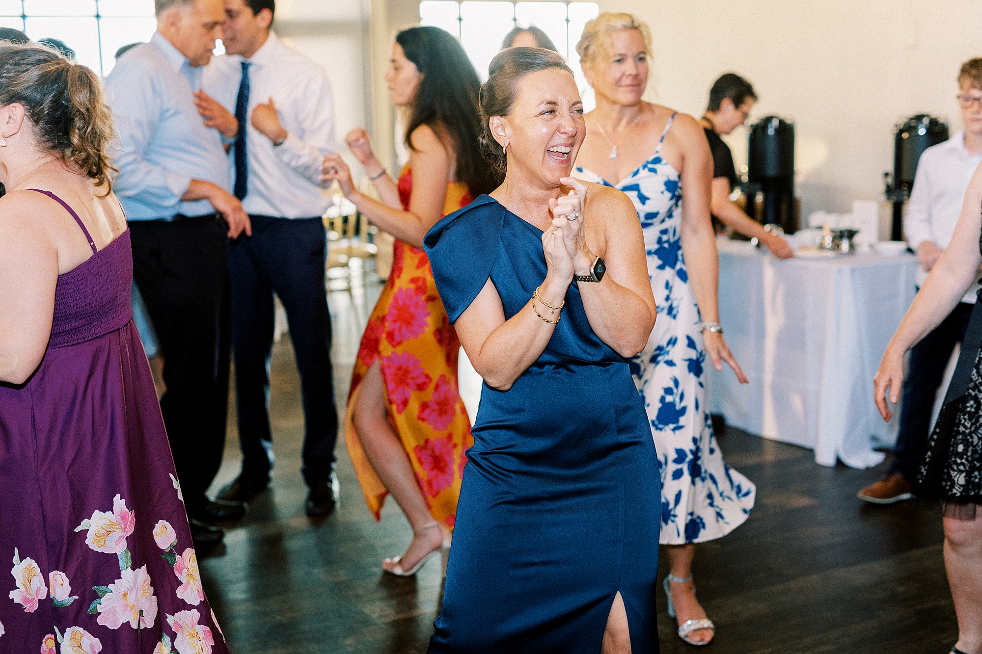 woman in navy dress dances at reception 
