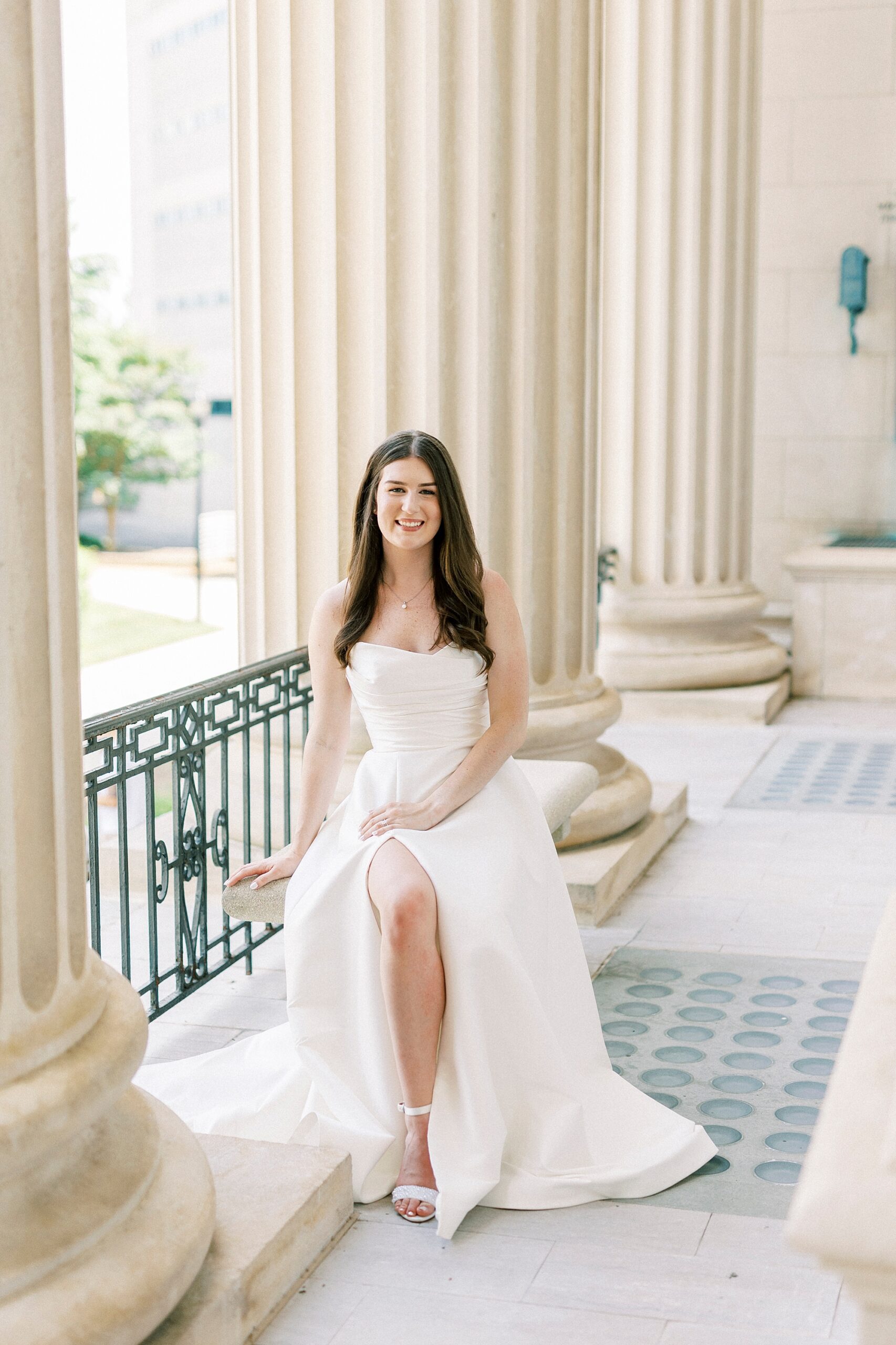 bride stands in strapless gown with slit in skirt