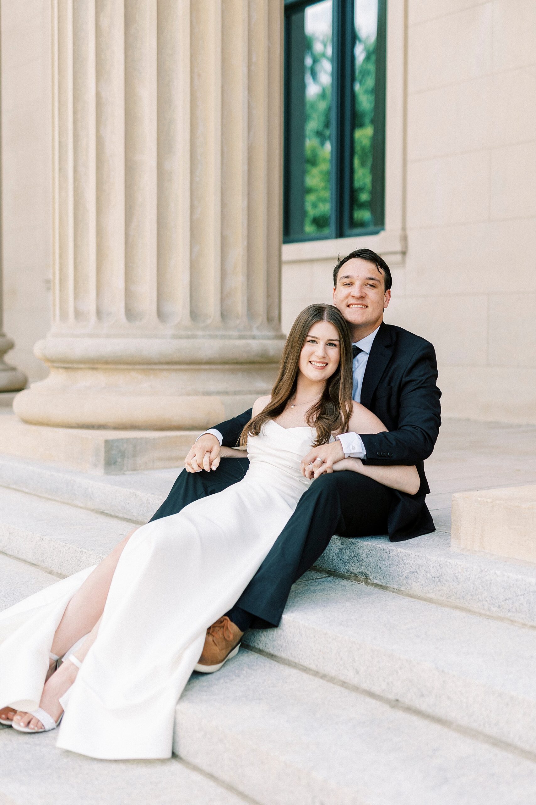bride and groom sit together on steps of building in Uptown Charlotte 