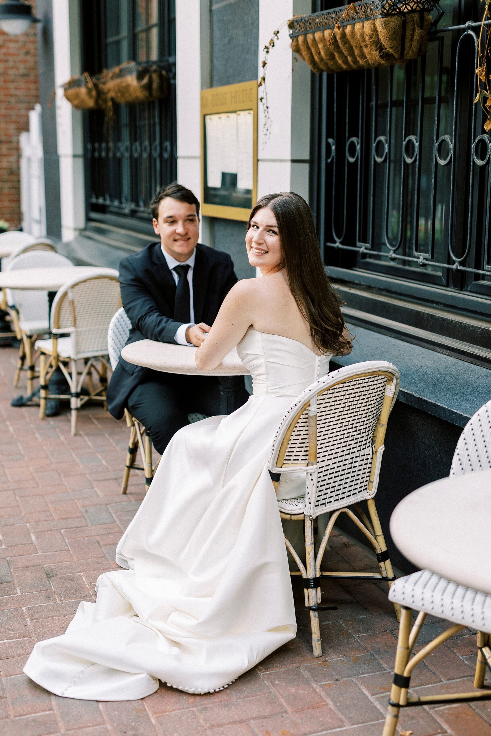 bride and groom sit outside cafe in Charlotte NC