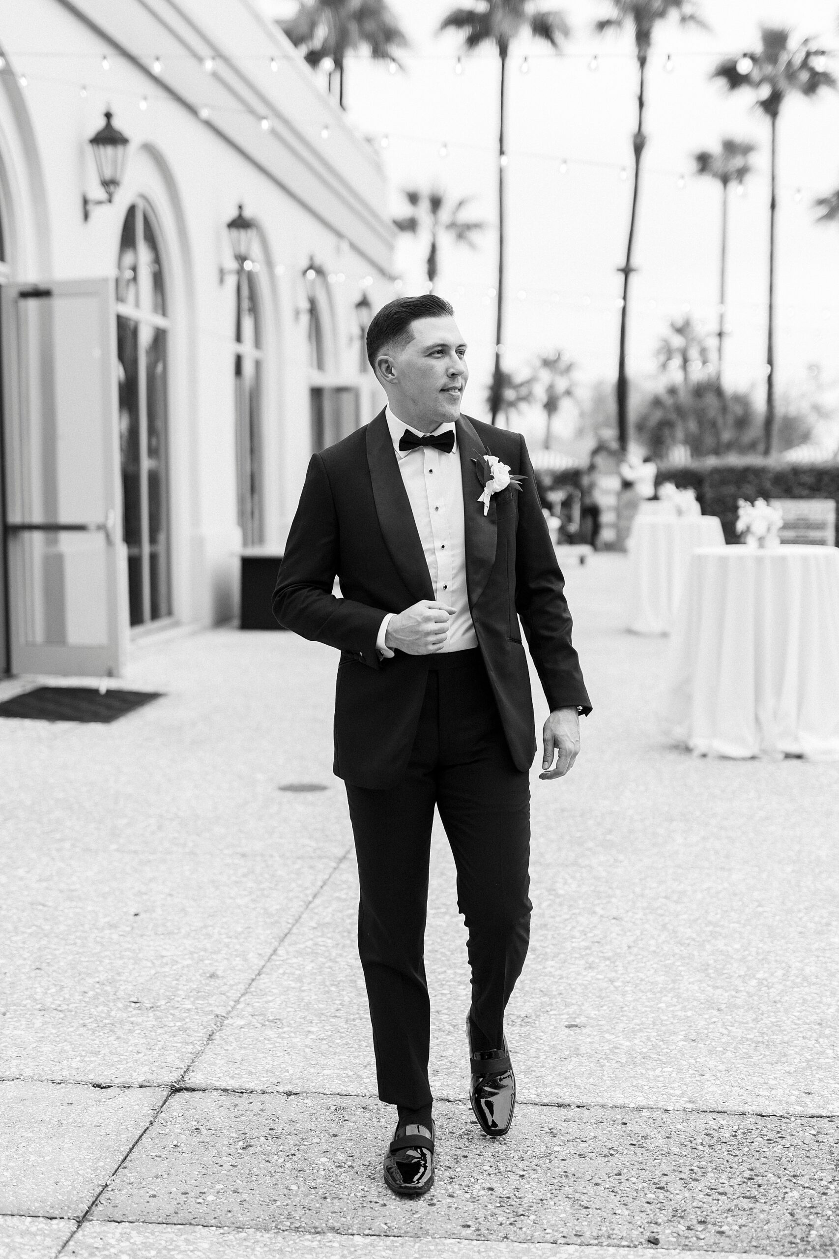 groom walking in front of building 