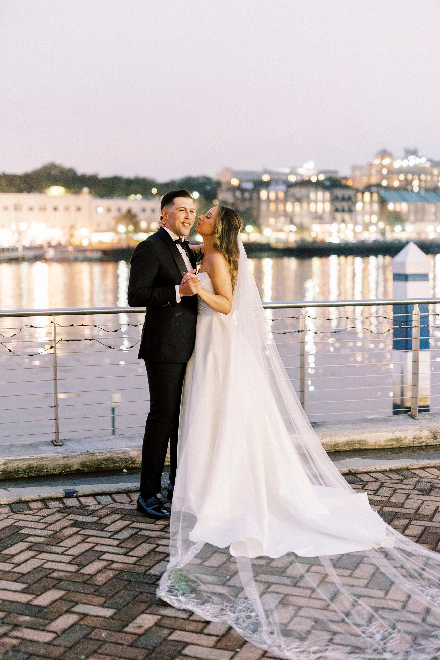 Savannah, GA wedding portraits by the riverfront with city in the background 