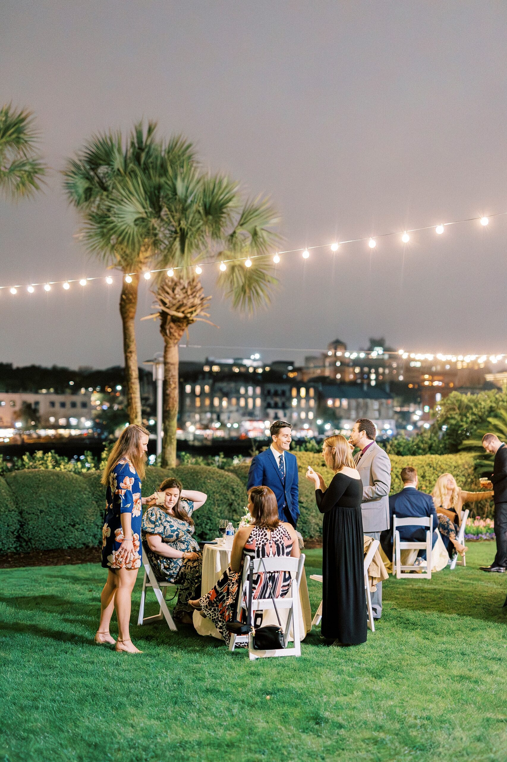wedding guests on the lawn under twinkling lights 