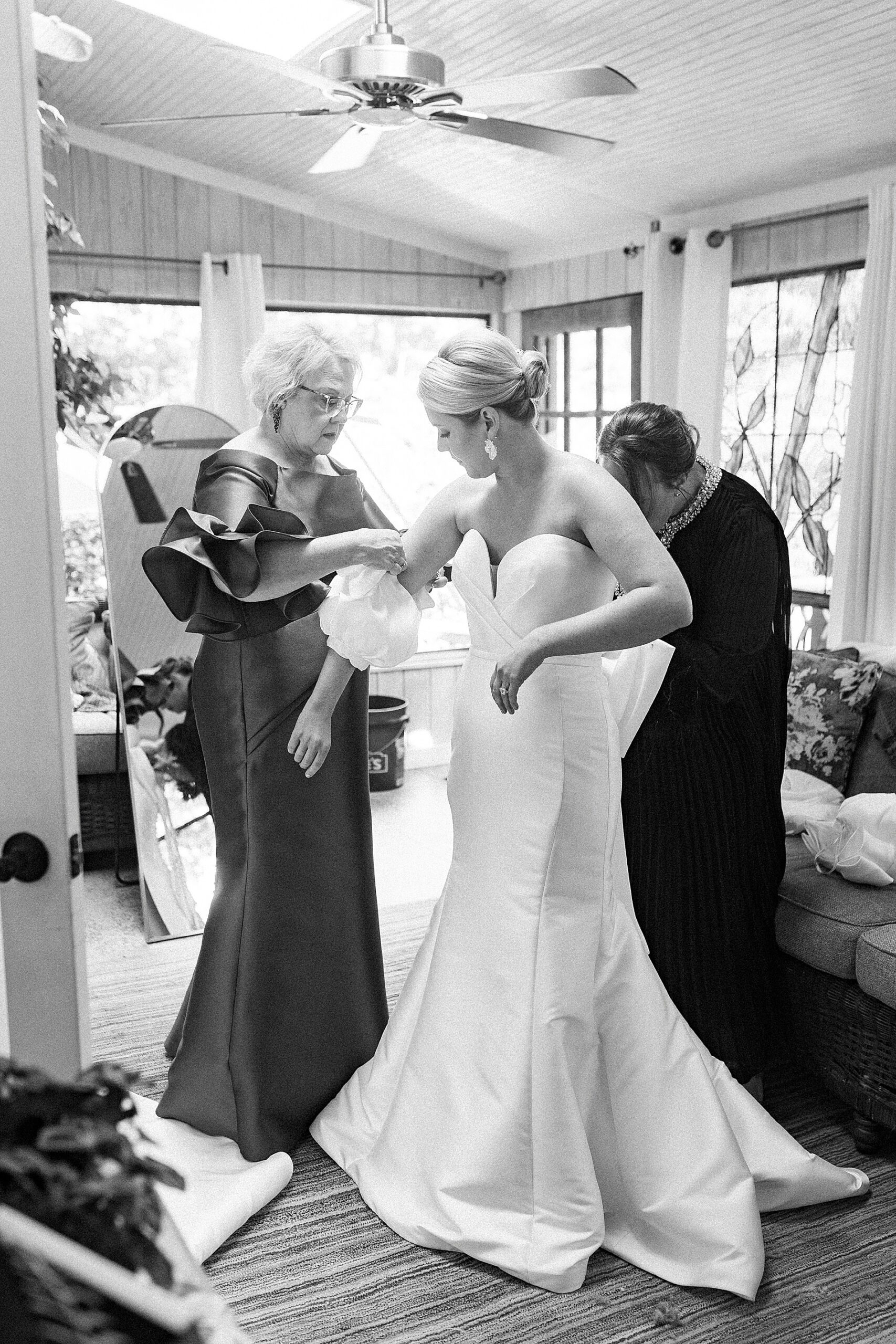 bride getting into dress with family