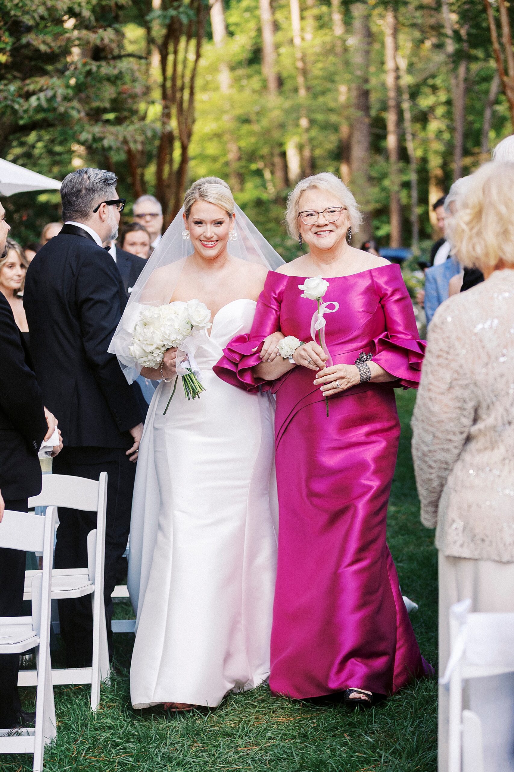 bride and mom walking together down aisle