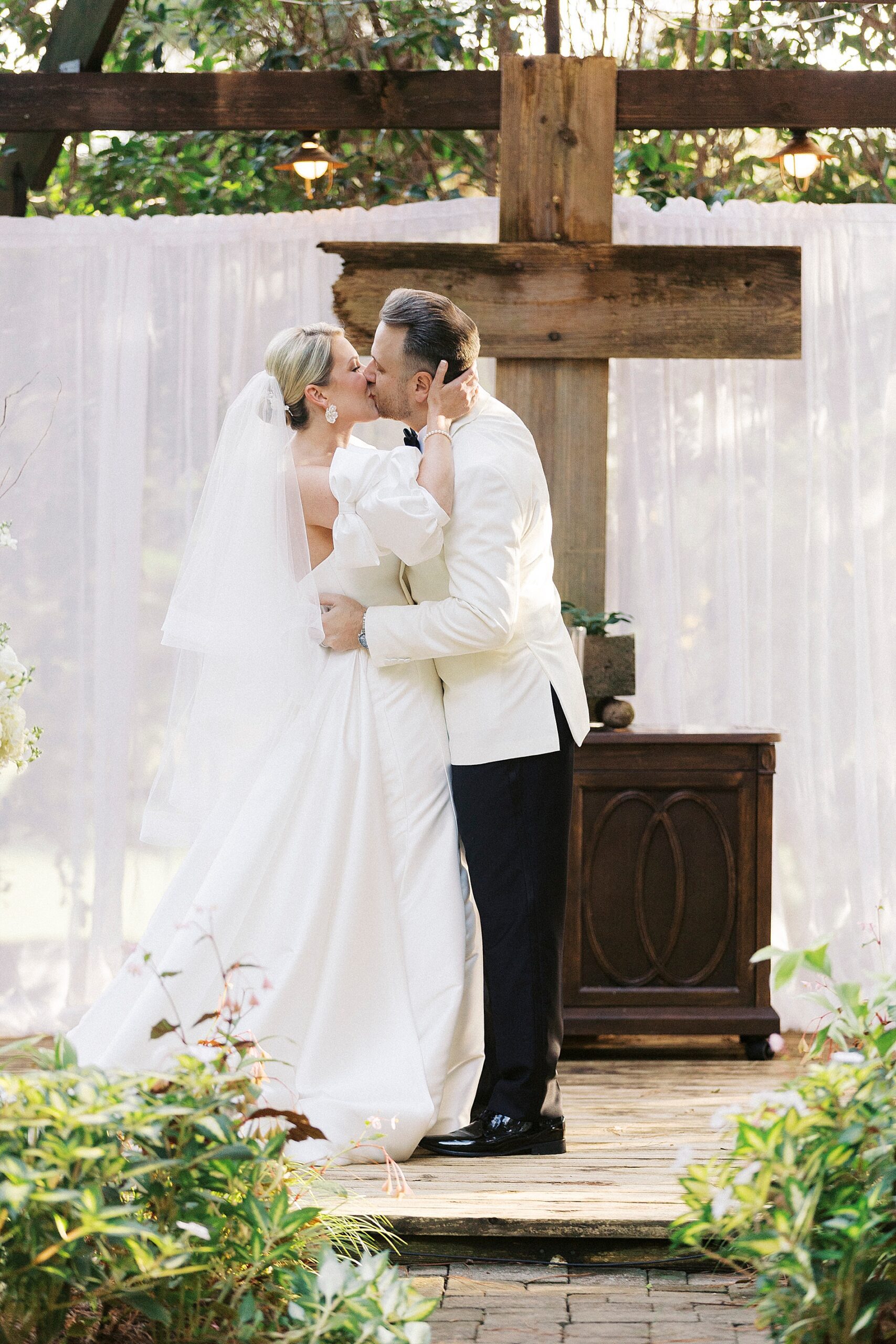 bride and groom kiss at wedding ceremony