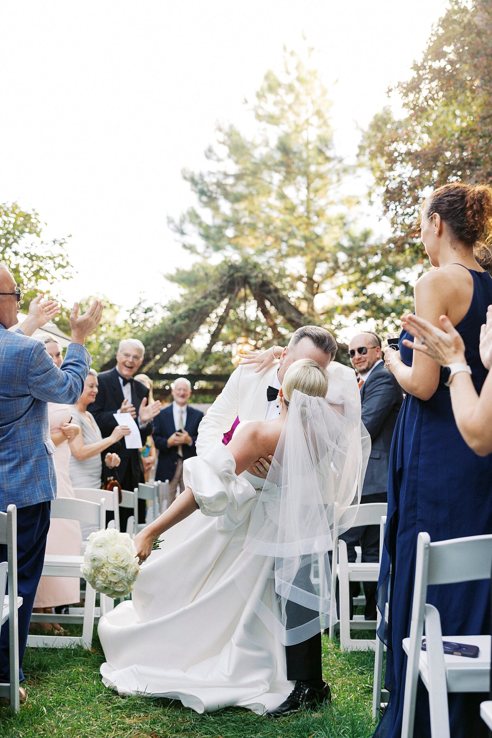 groom kisses and dips bride as they exit wedding ceremony