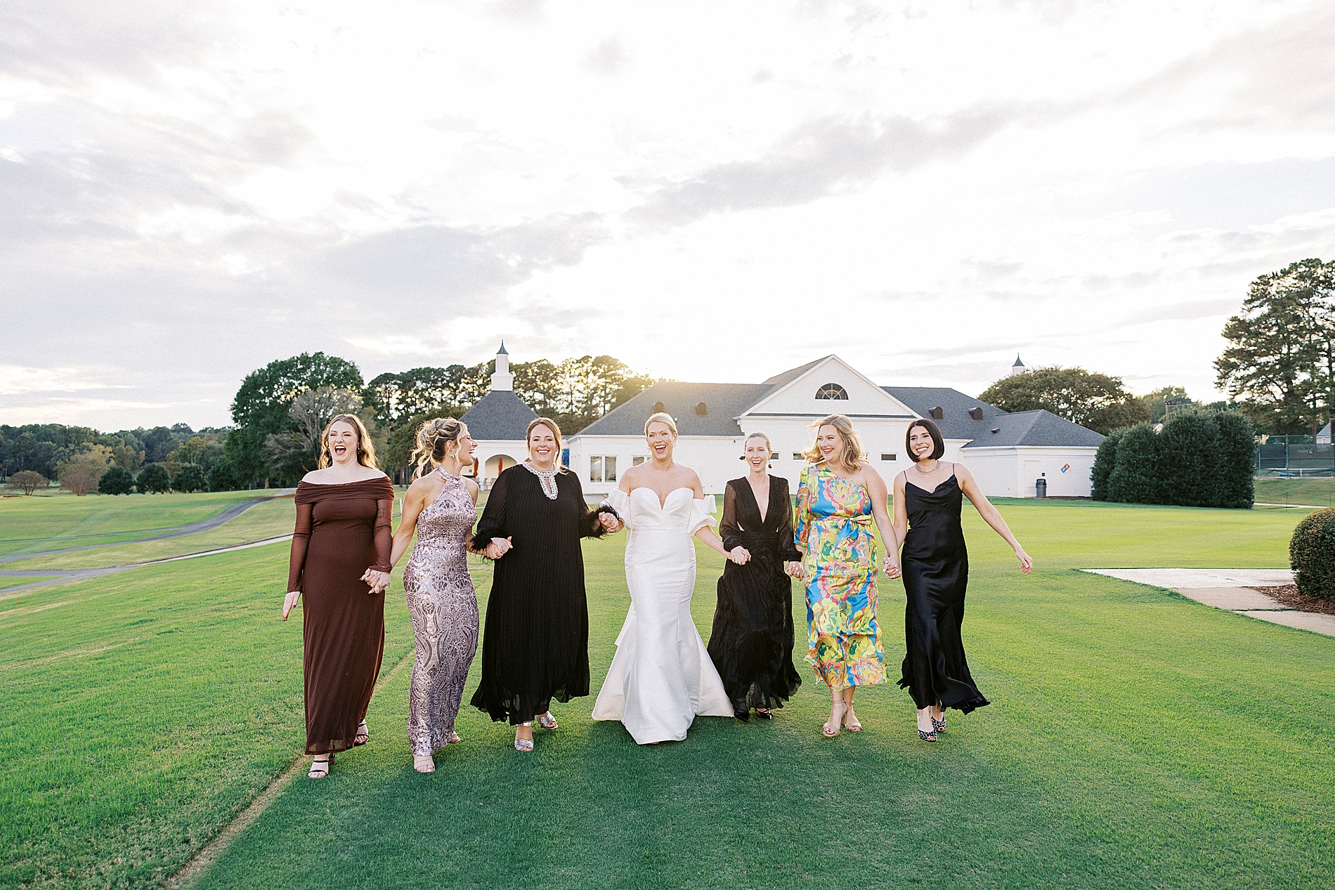 bride and bridesmaids walk together holding hands