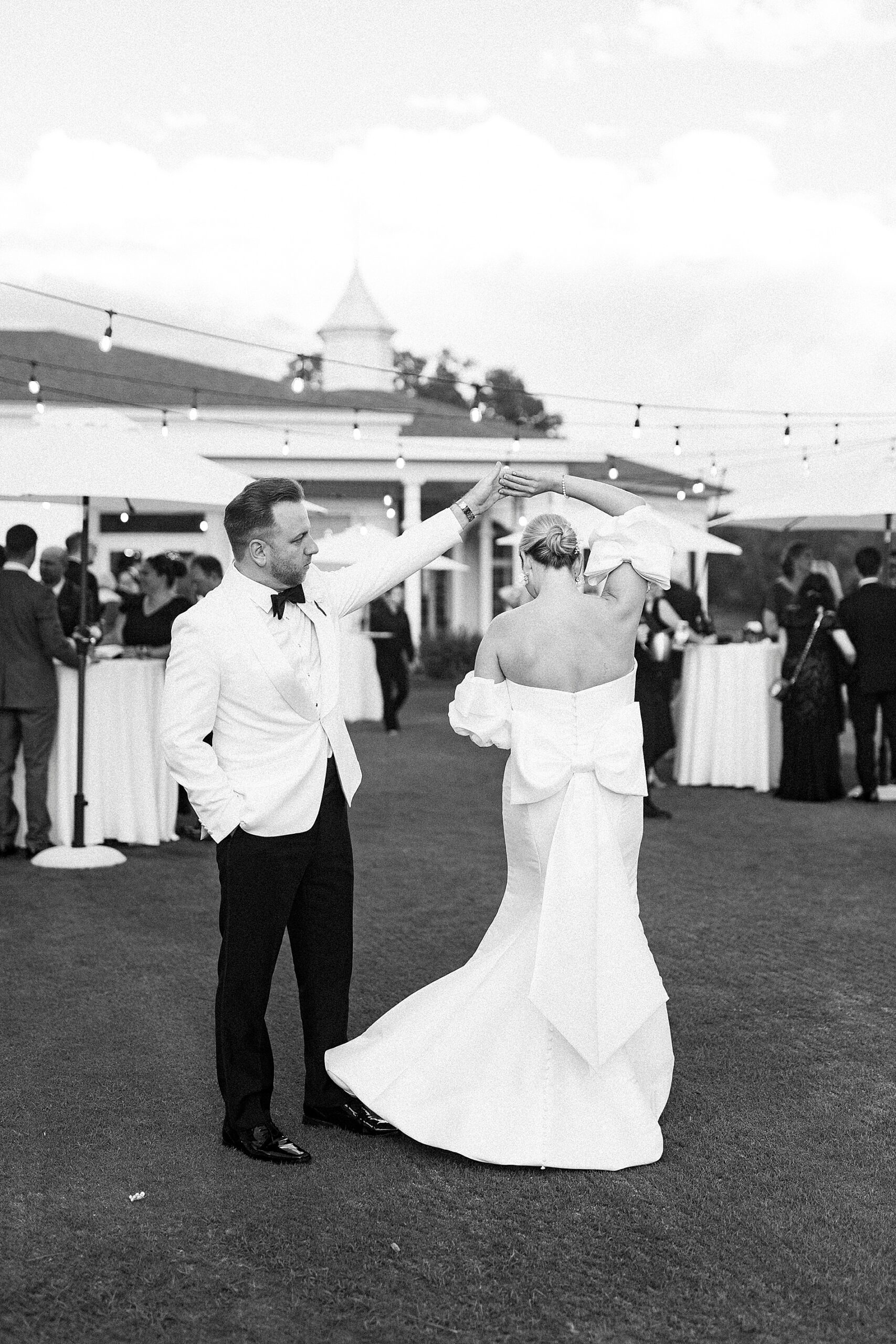 bride and groom dance on lawn during cocktail hour