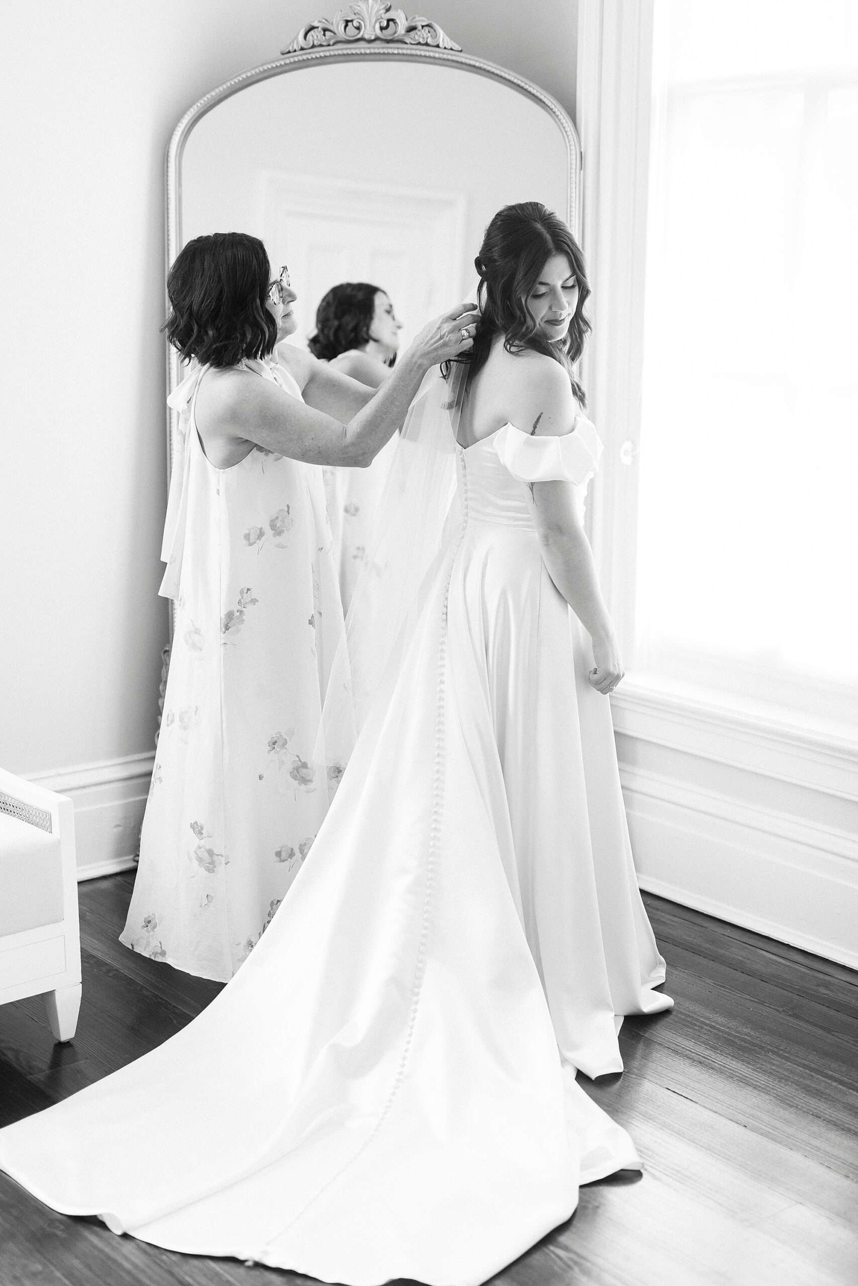 woman helping bride with veil 