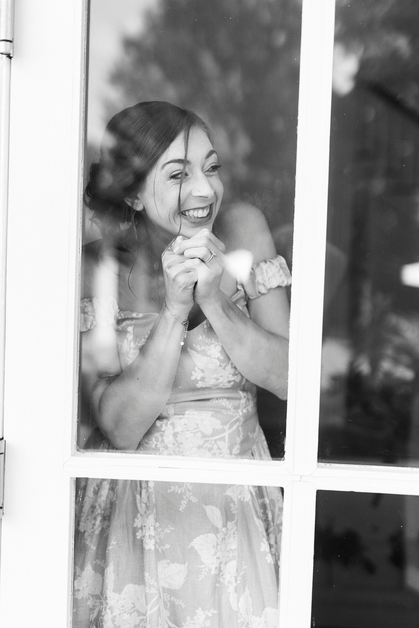 bridesmaid looking excitedly out window for father-daughter first look