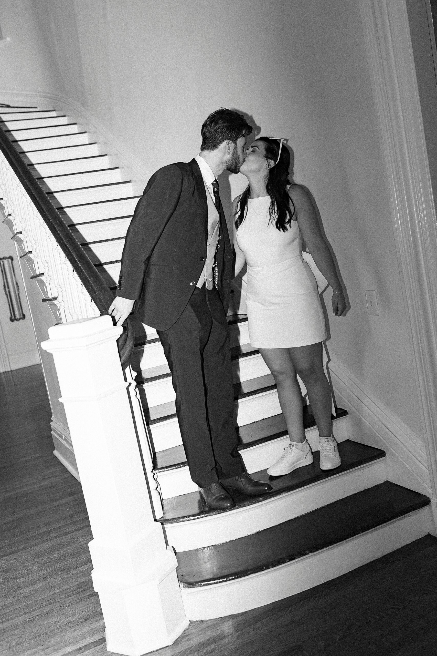 bride and groom kiss on staircase