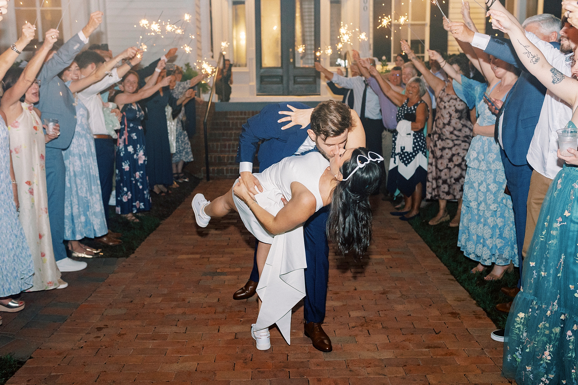 romantic portraits of newlyweds kissing as they exit wedding reception 