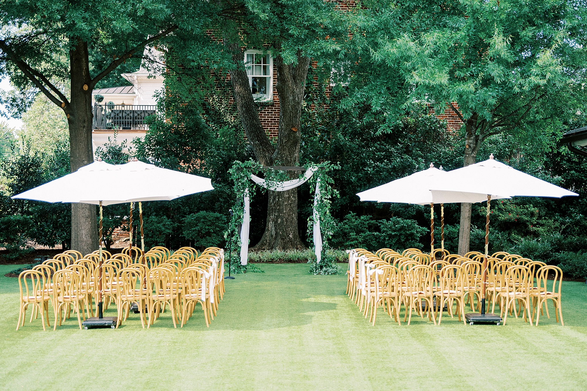 outdoor wedding ceremony with umbrellas over chairs 