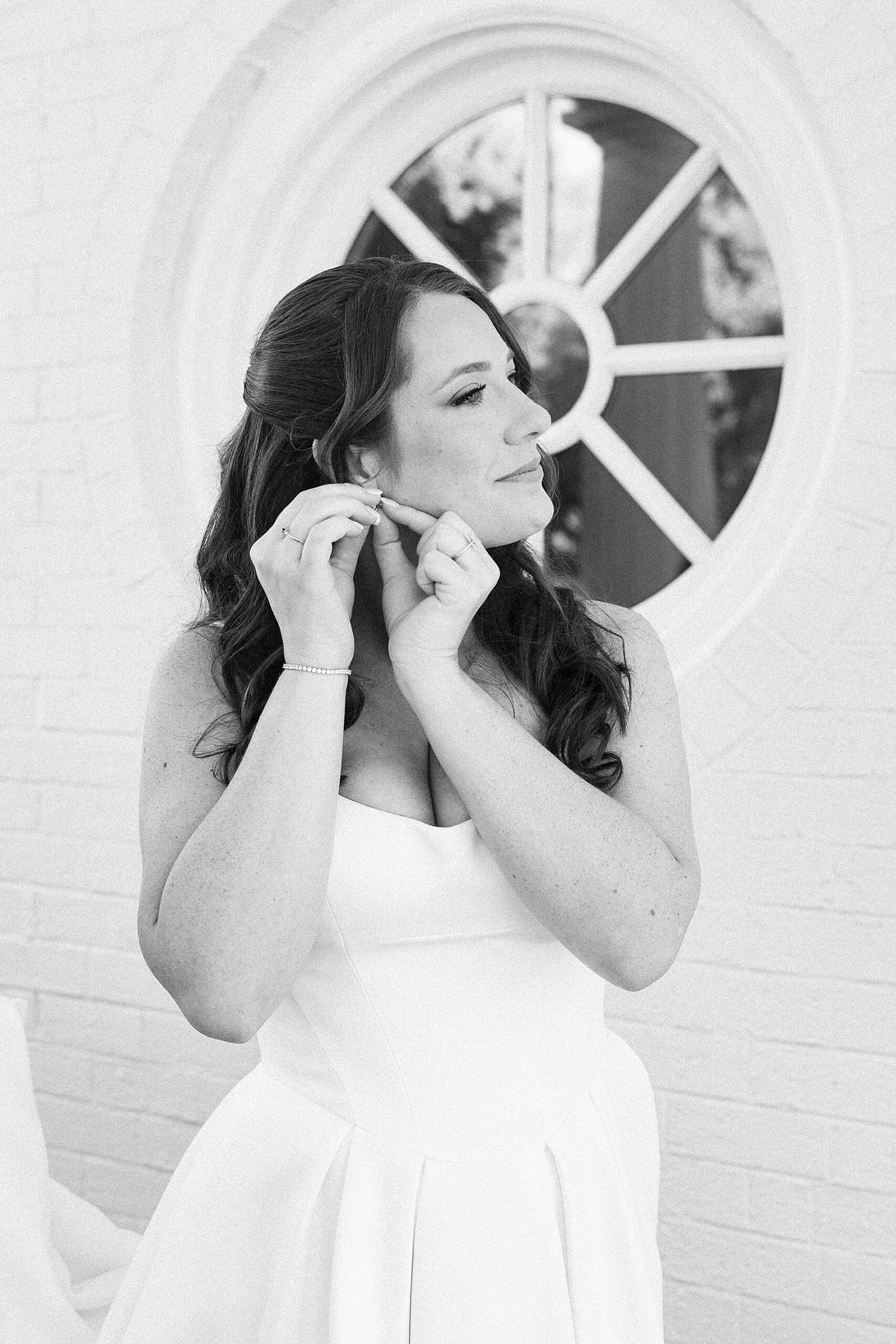 bride putting earrings in 