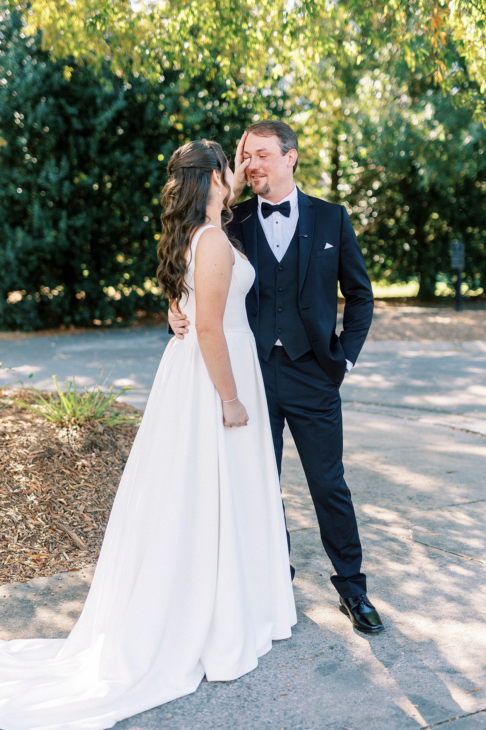 bride wipes away tear from groom during first look