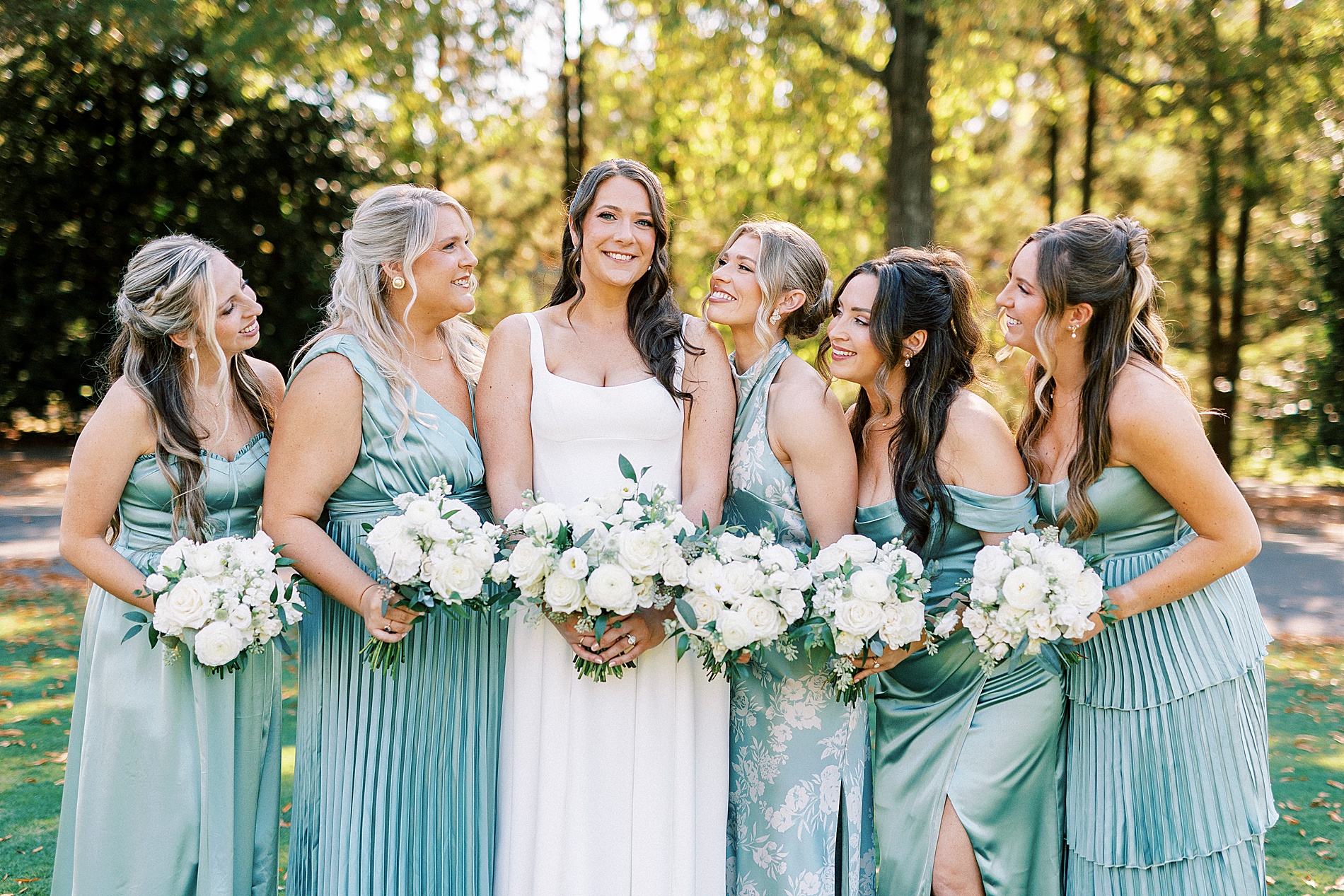bridal party portraits with bridesmaids in different styles of teal dresses 