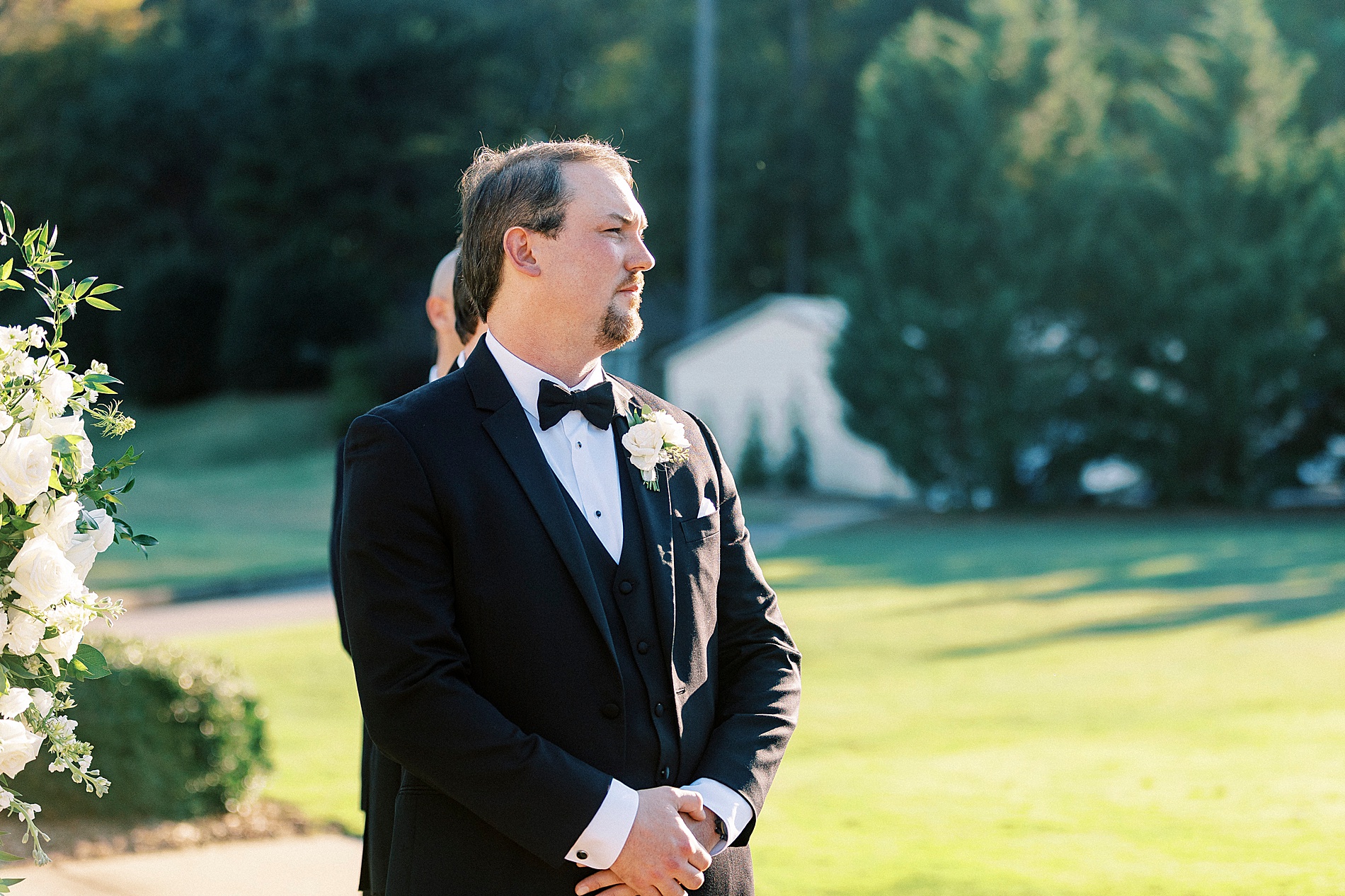 groom watches bride walk down the aisle 
