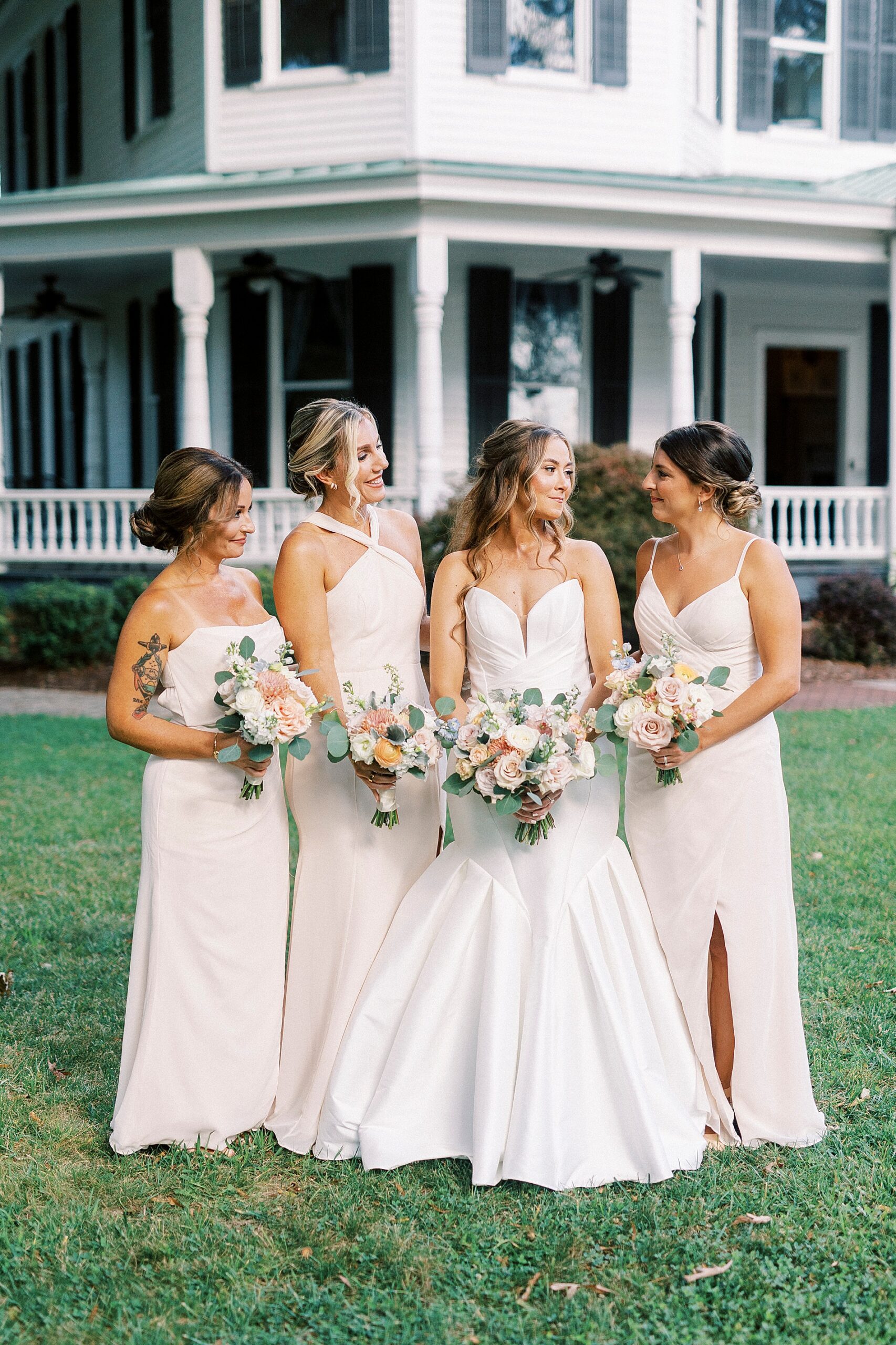 bridesmaids in soft pink dress with bride outside of The Brawley Estate in Mooresville, NC