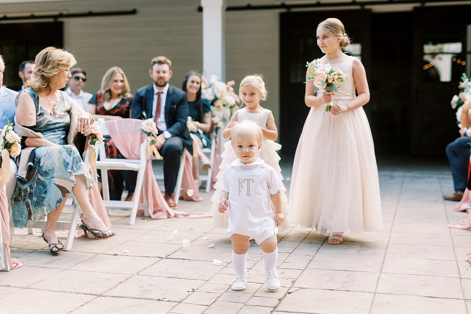 flower girls and ring bearer walk down asile