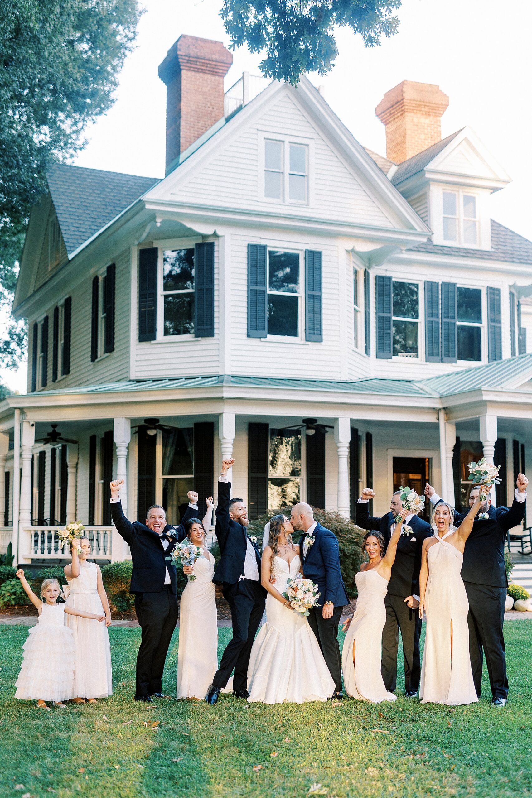 wedding party cheer as they stand with bride and groom