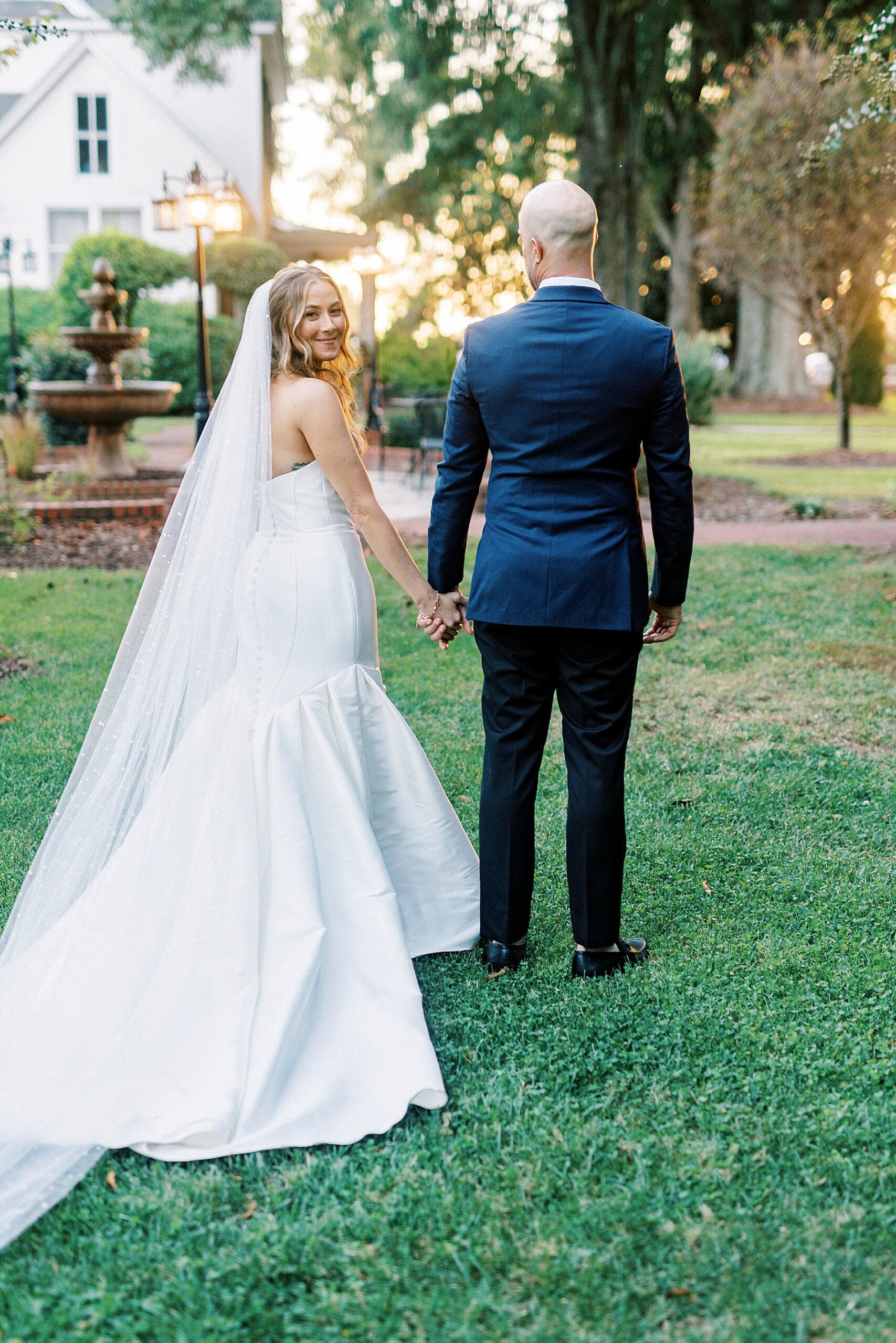 bride and groom walk together holding hands