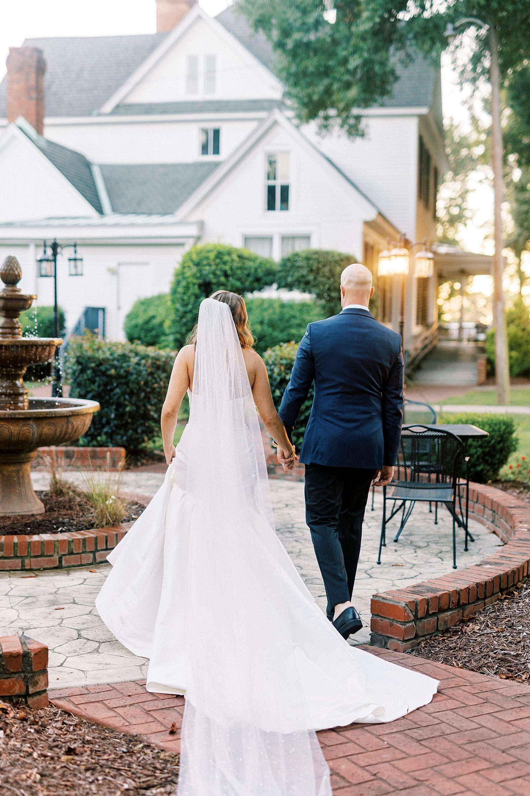 bride and groom walk towards The Brawley Estate