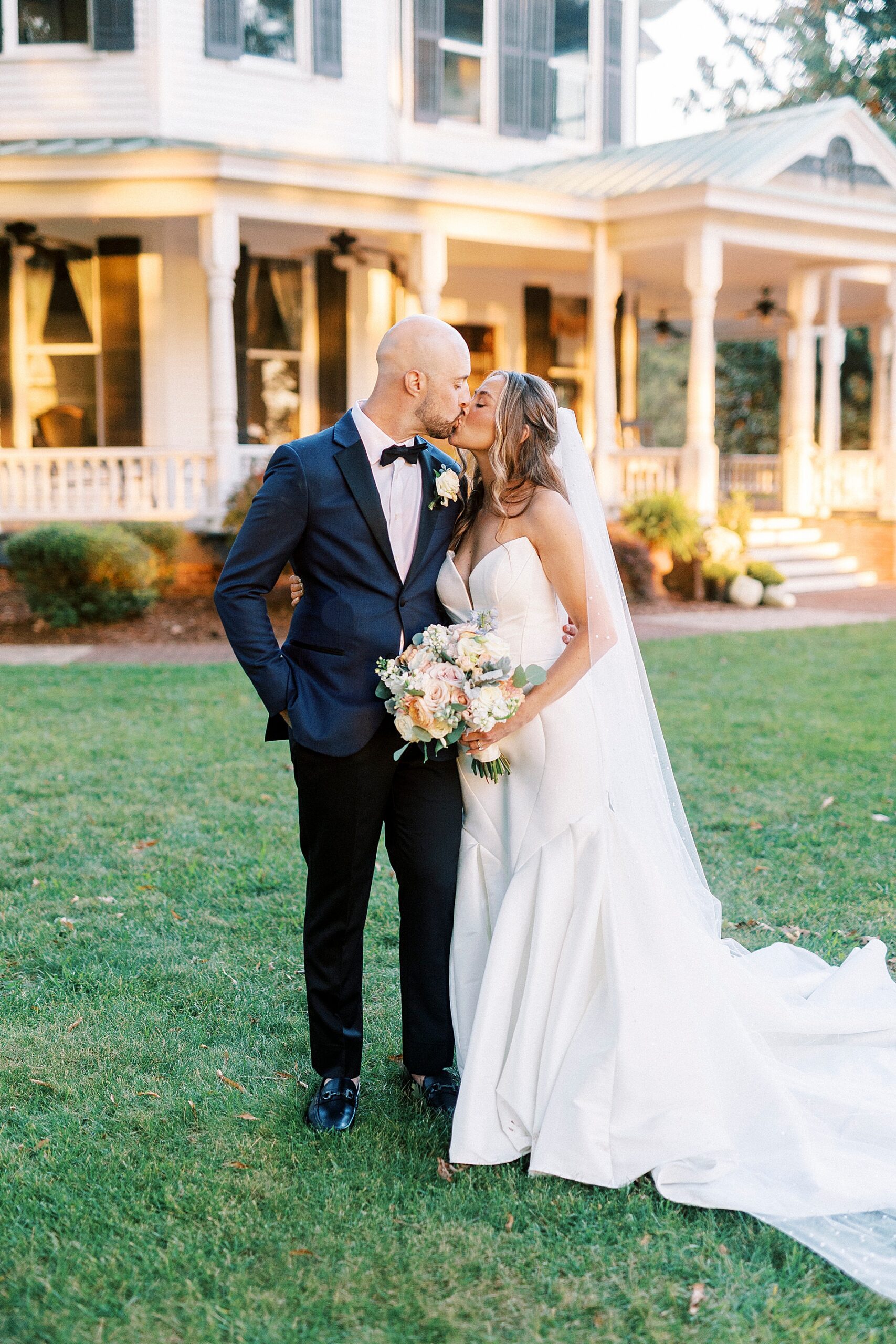 romantic wedding portraits of couple kissing outside of estate