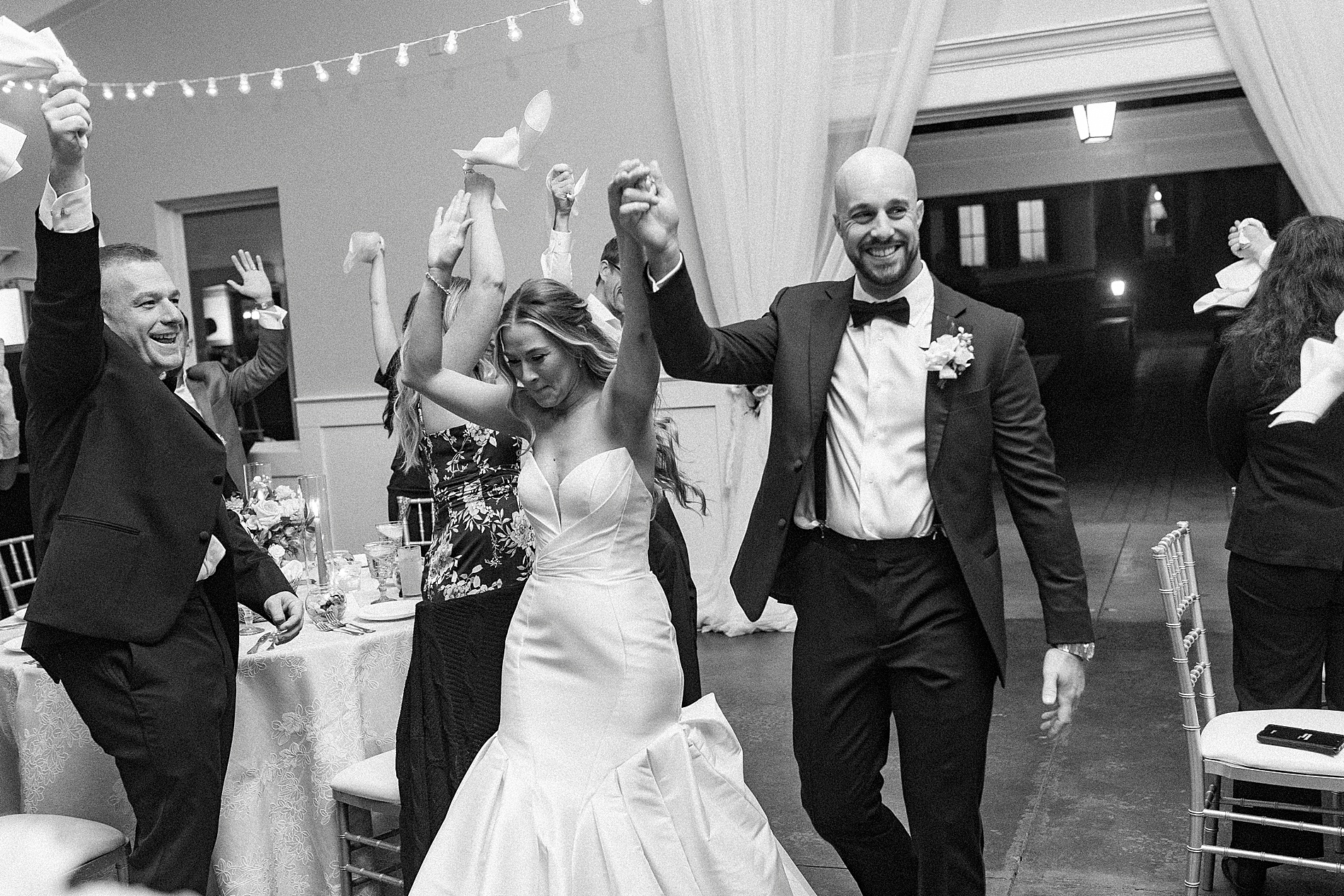newlyweds holding hands as they enter wedding reception