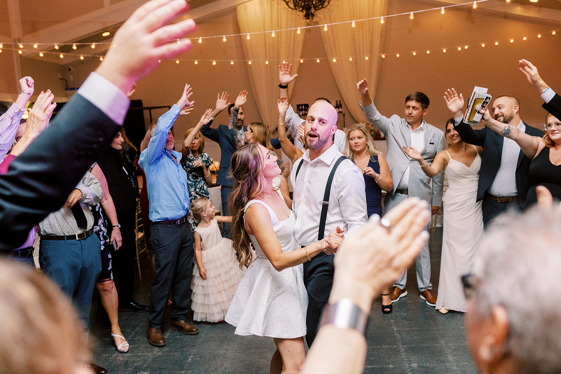 newlyweds on dance floor with guests