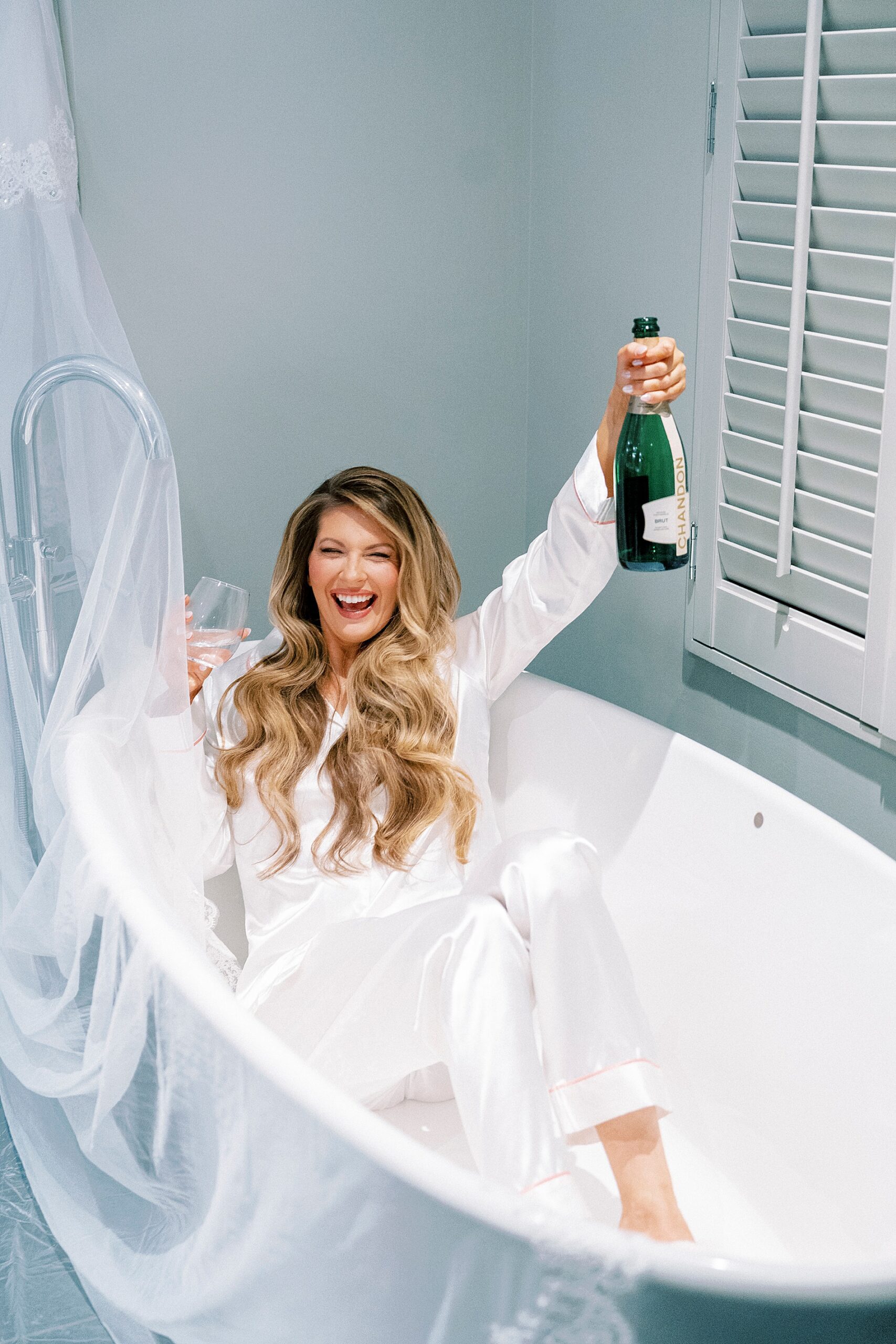 bride in bathtub holding champagne 