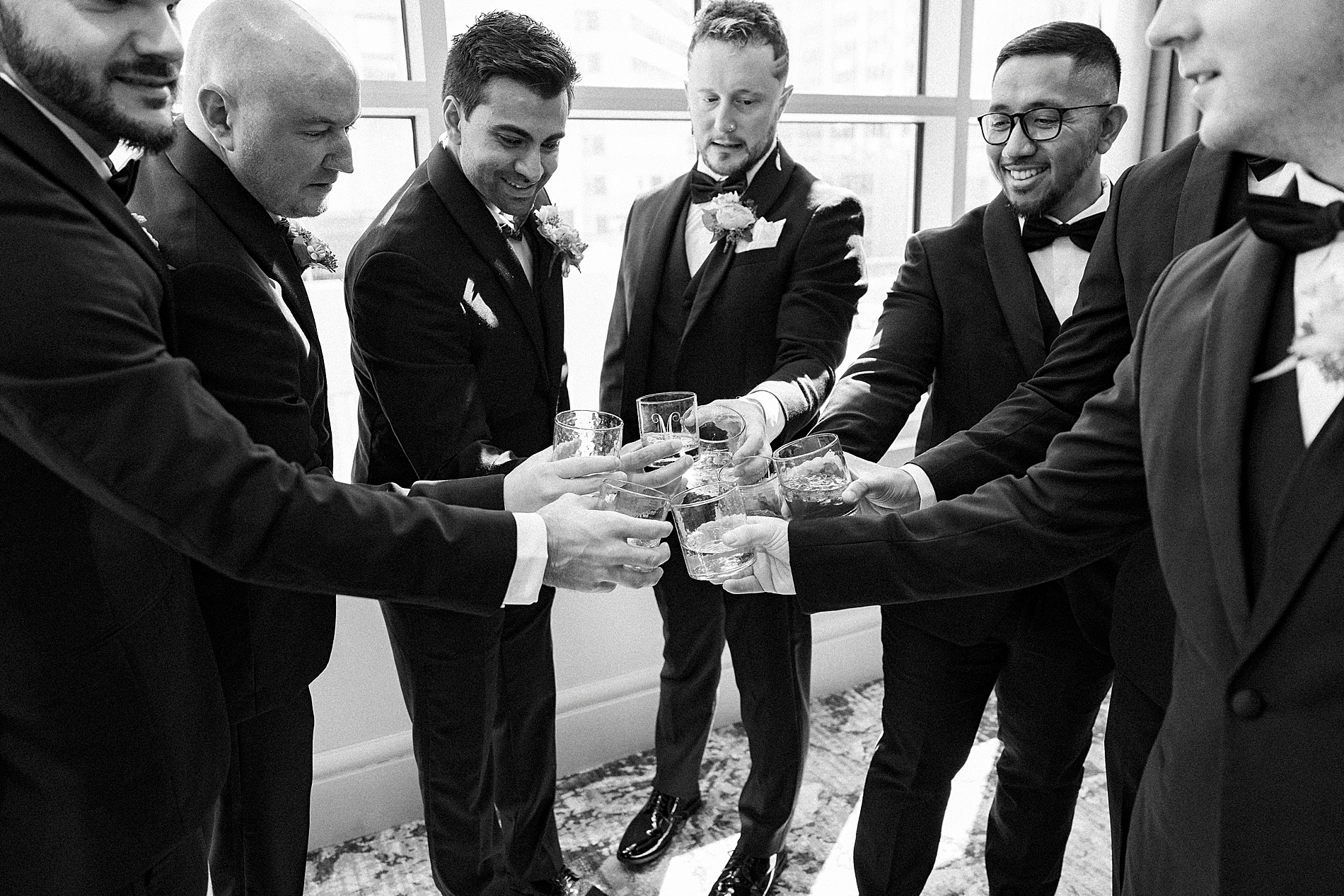 groom and groomsmen cheers while getting ready 