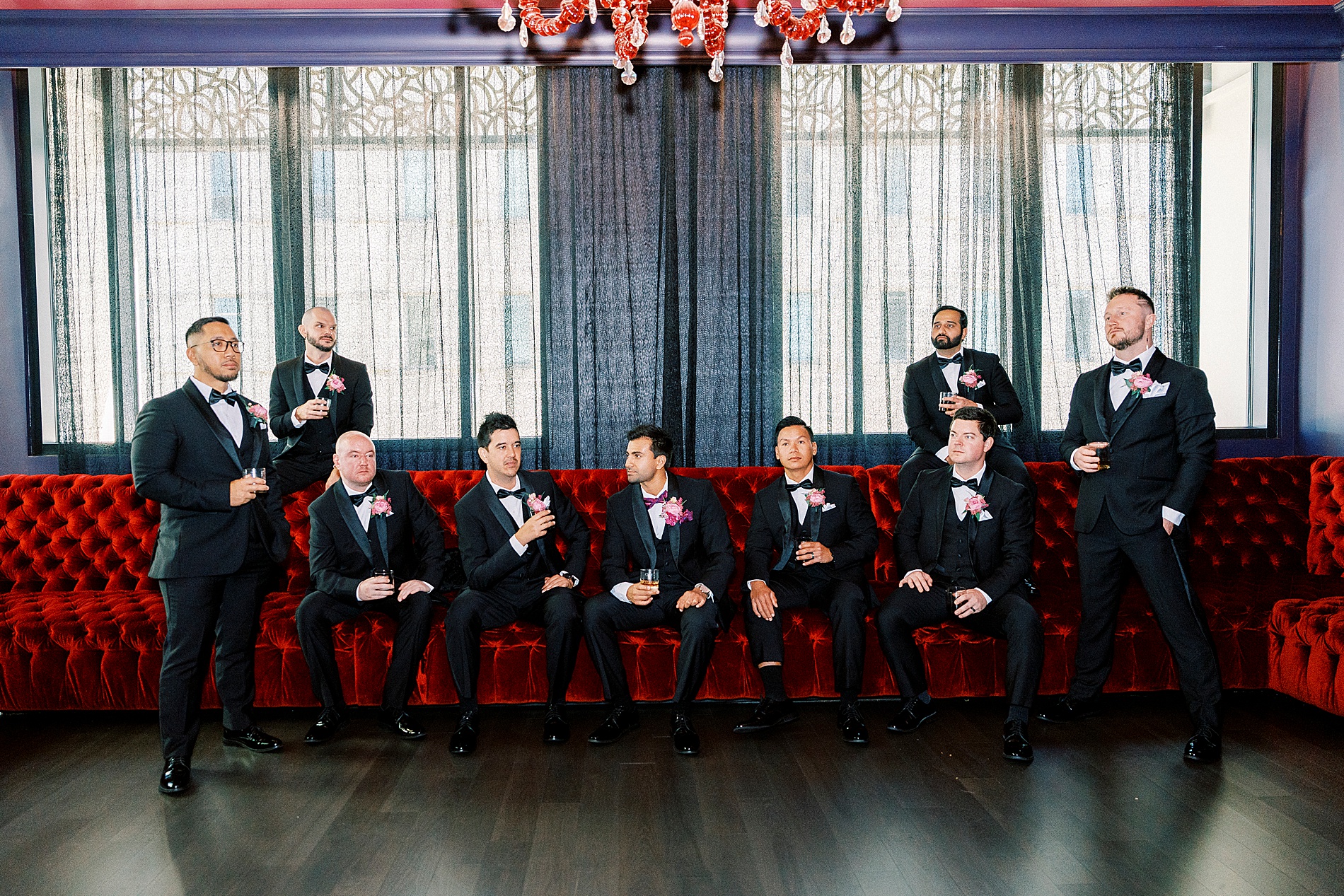 groom and groomsmen sitting on red bench at The Grand Bohemian Hotel  