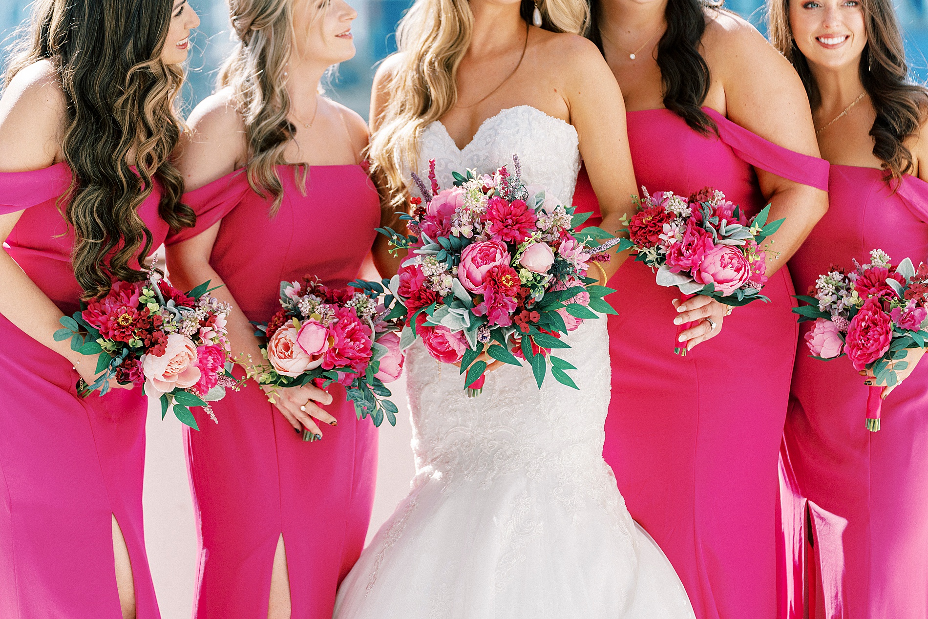 bride and bridesmaids in magenta dresses with pink flower bouquets 
