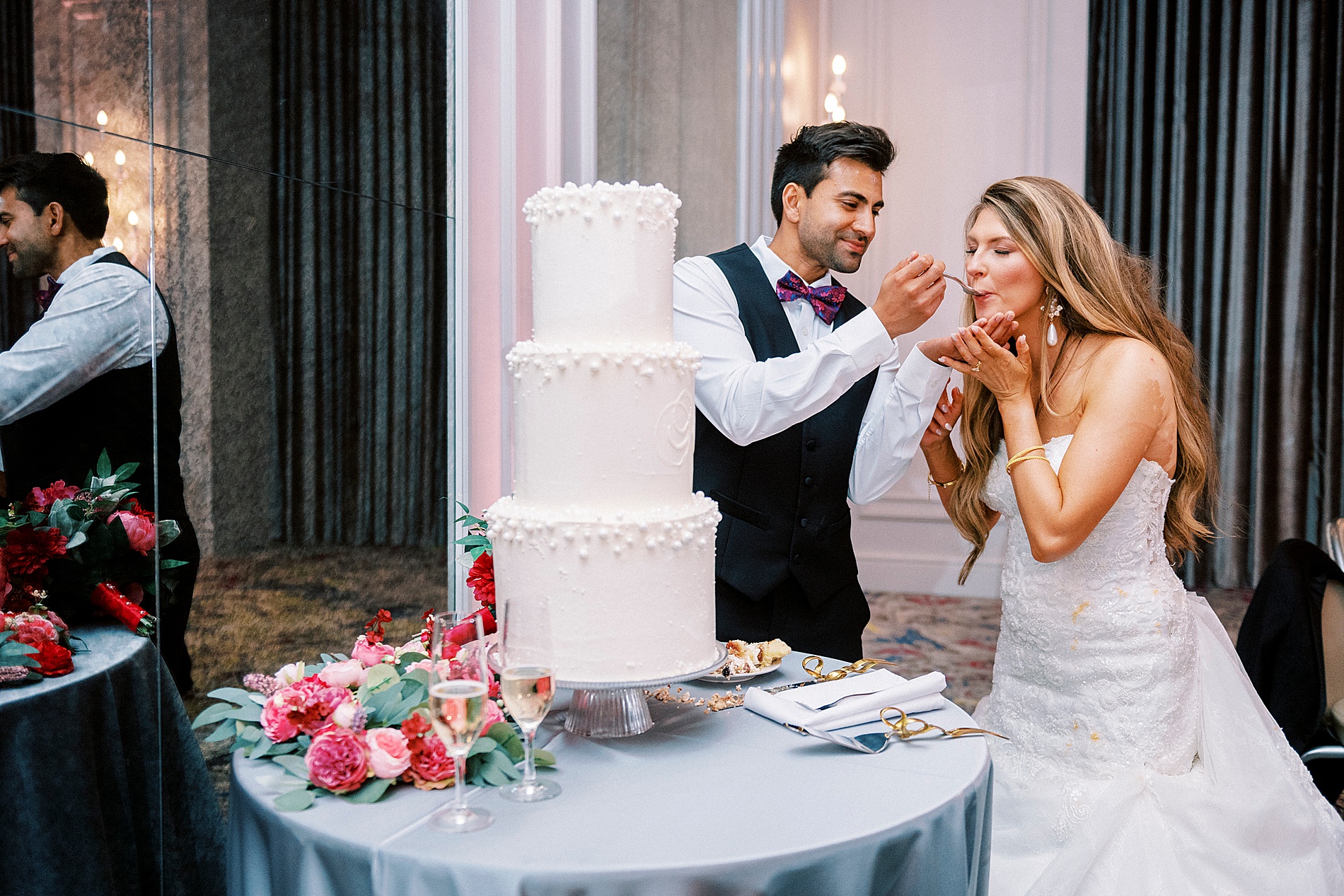 bride and groom feed each other wedding cake 