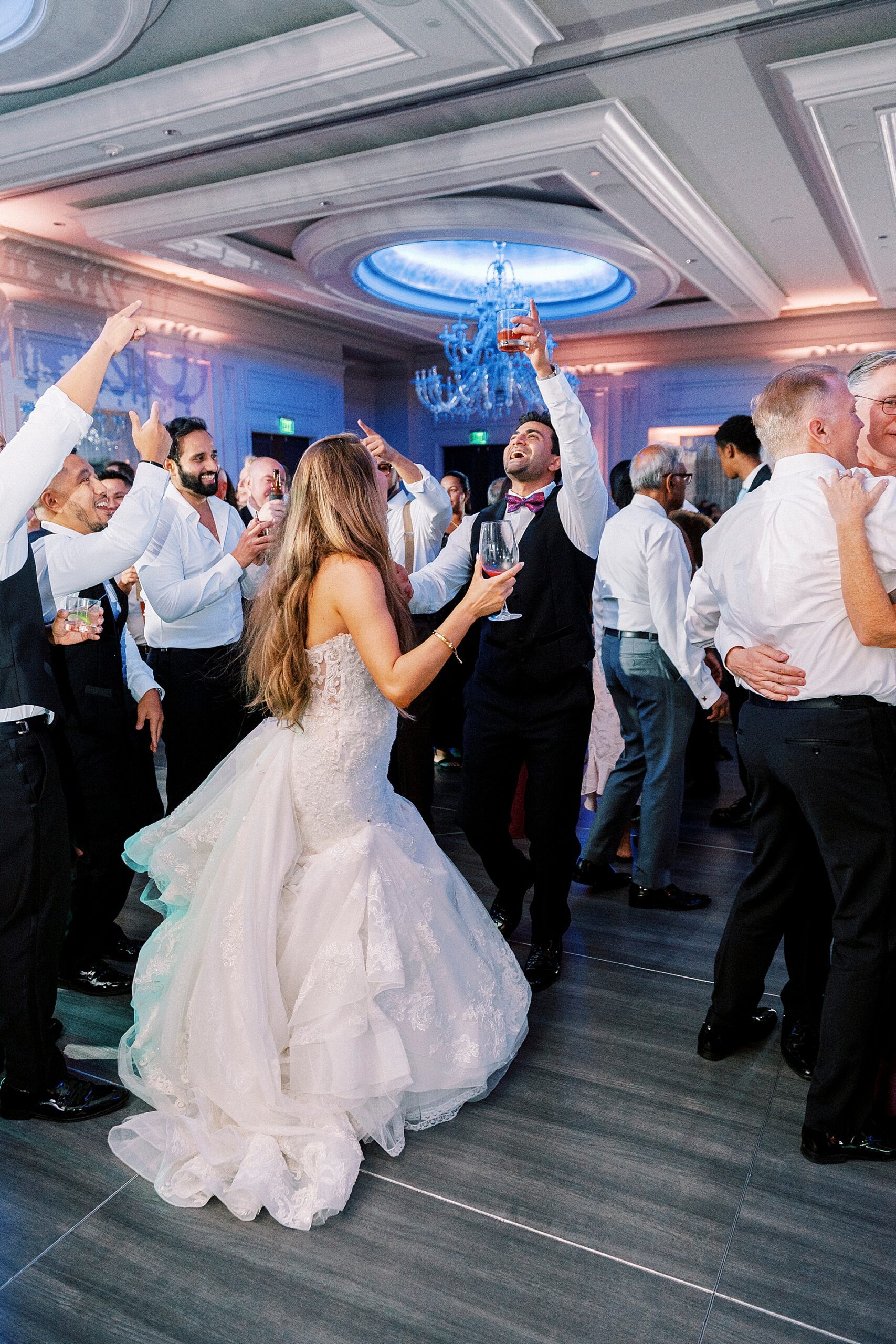 newlyweds on dance floor surrounded with guests 