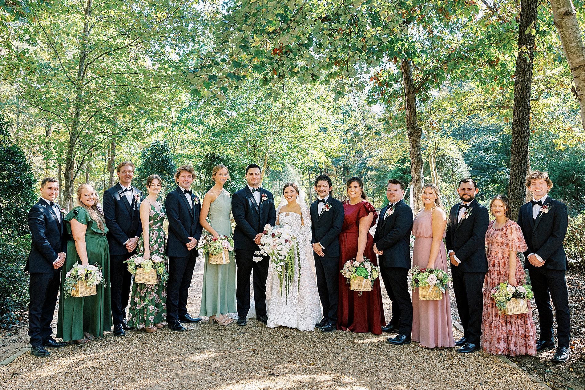 wedding party portraits with bridesmaids in various floral dresses with bouquets in basket
