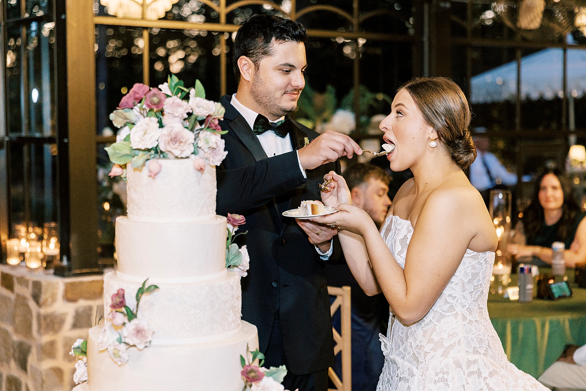 groom feeds bride wedding cake 