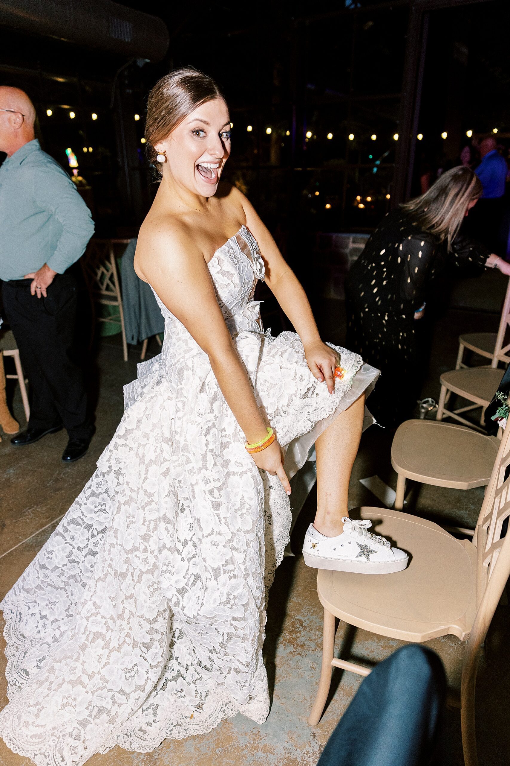bride showing off wedding tennis shoes 