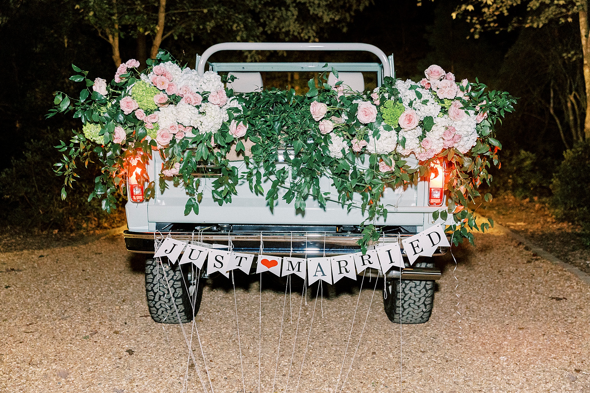 vintage bronco decorated with flowers and just married sign 