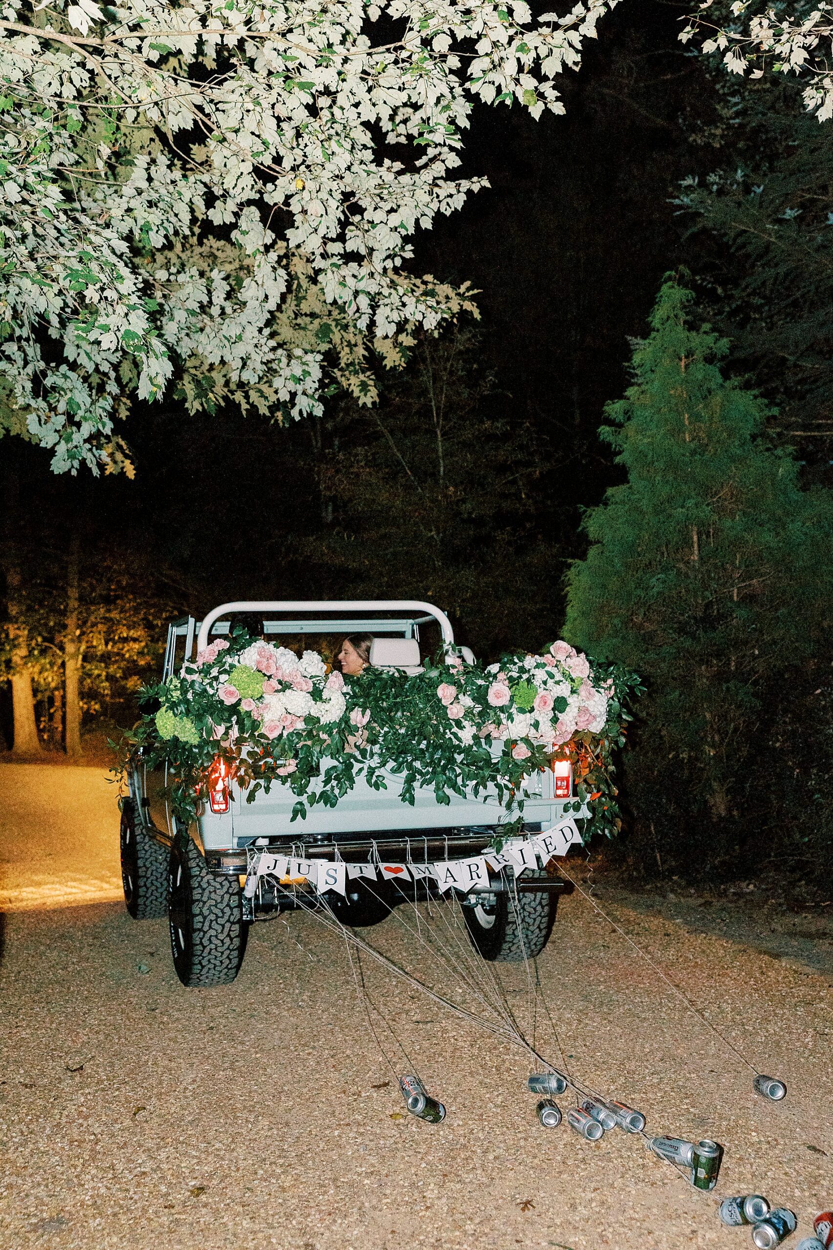 vintage bronco decorated with flowers and just married sign 
