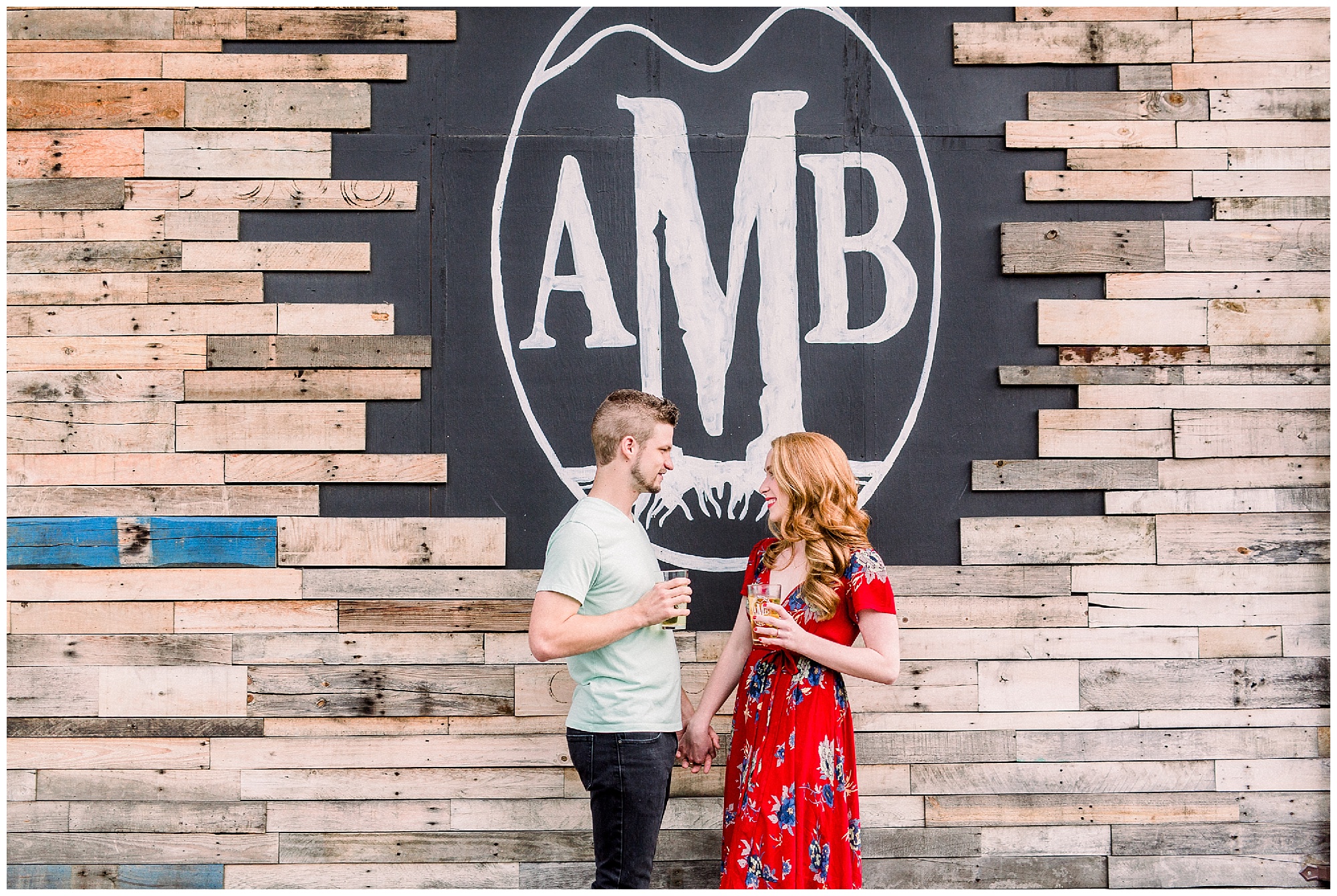 couple holds hands in front of Appalachian Mountain Brewery sign