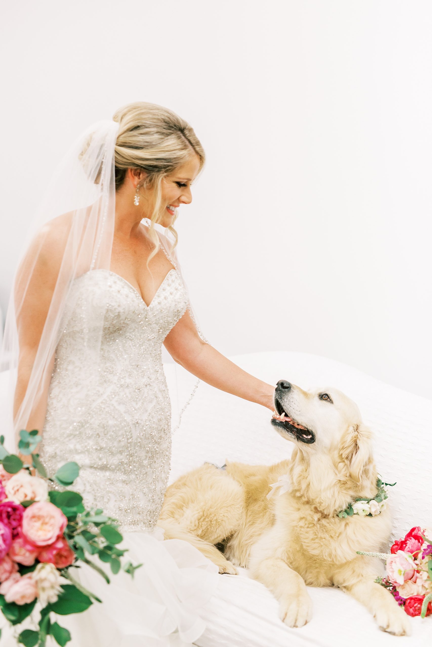 bride pets dog with flower collar