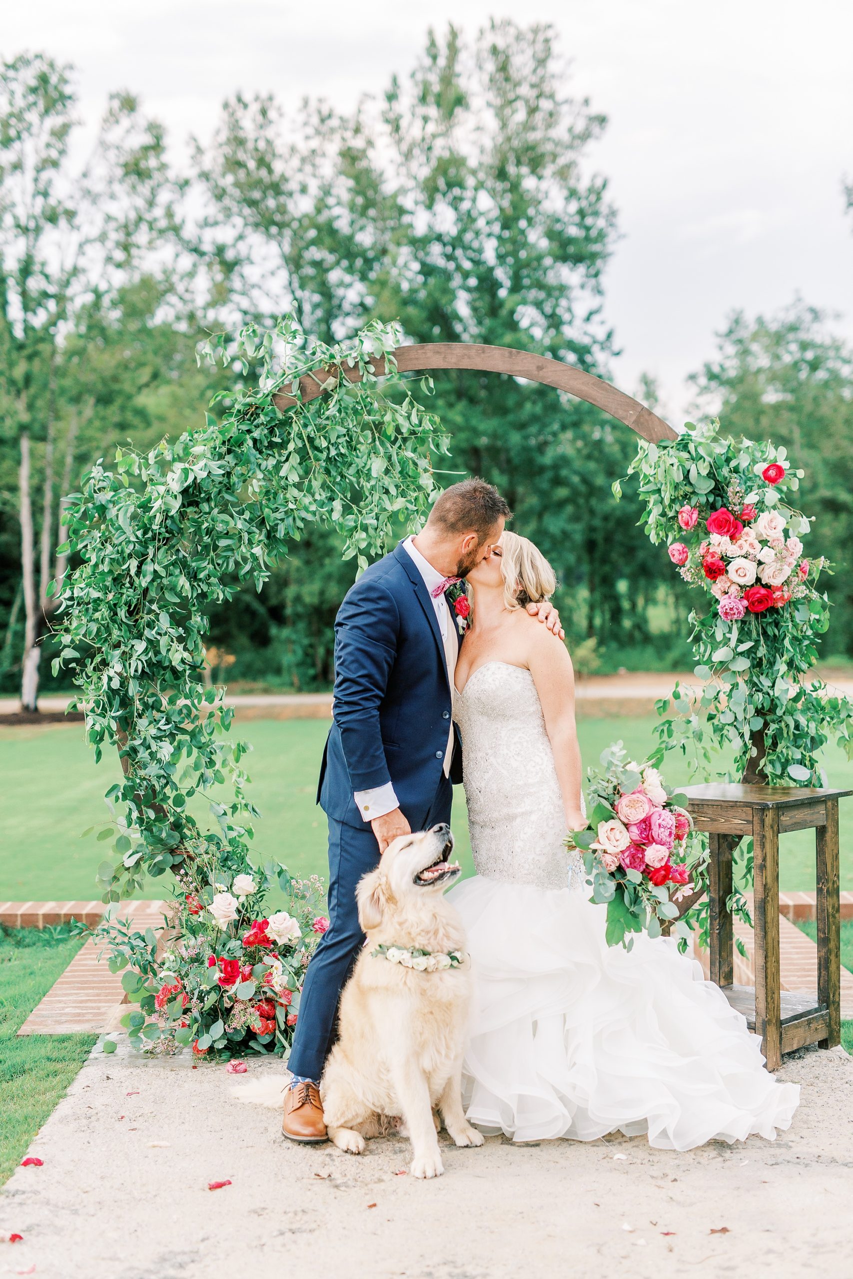 newlyweds kiss with dog in front of them